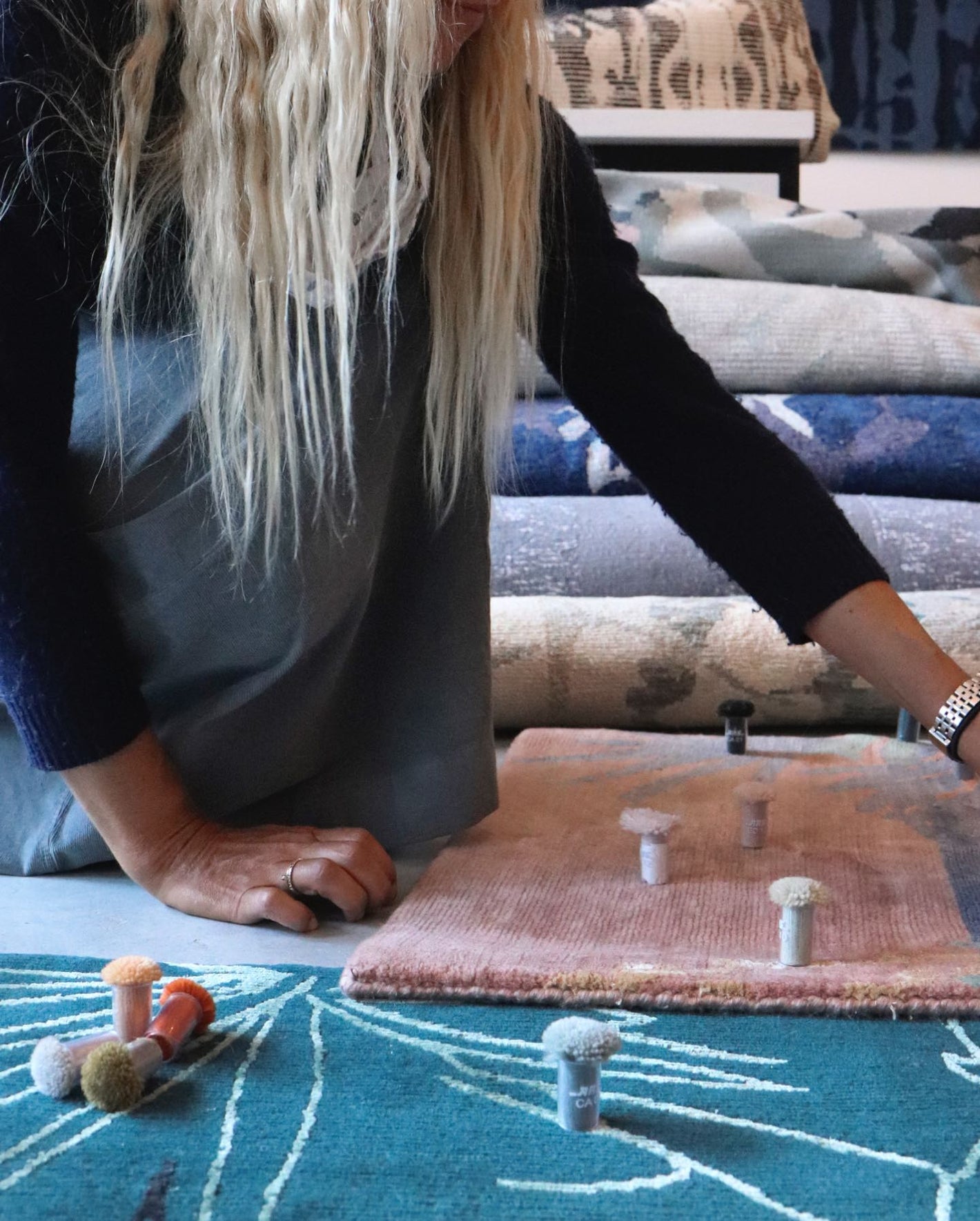 A woman is working on a rug in a store
