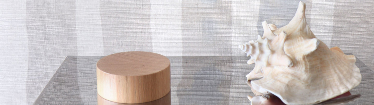 A wooden box next to a seashell on a table