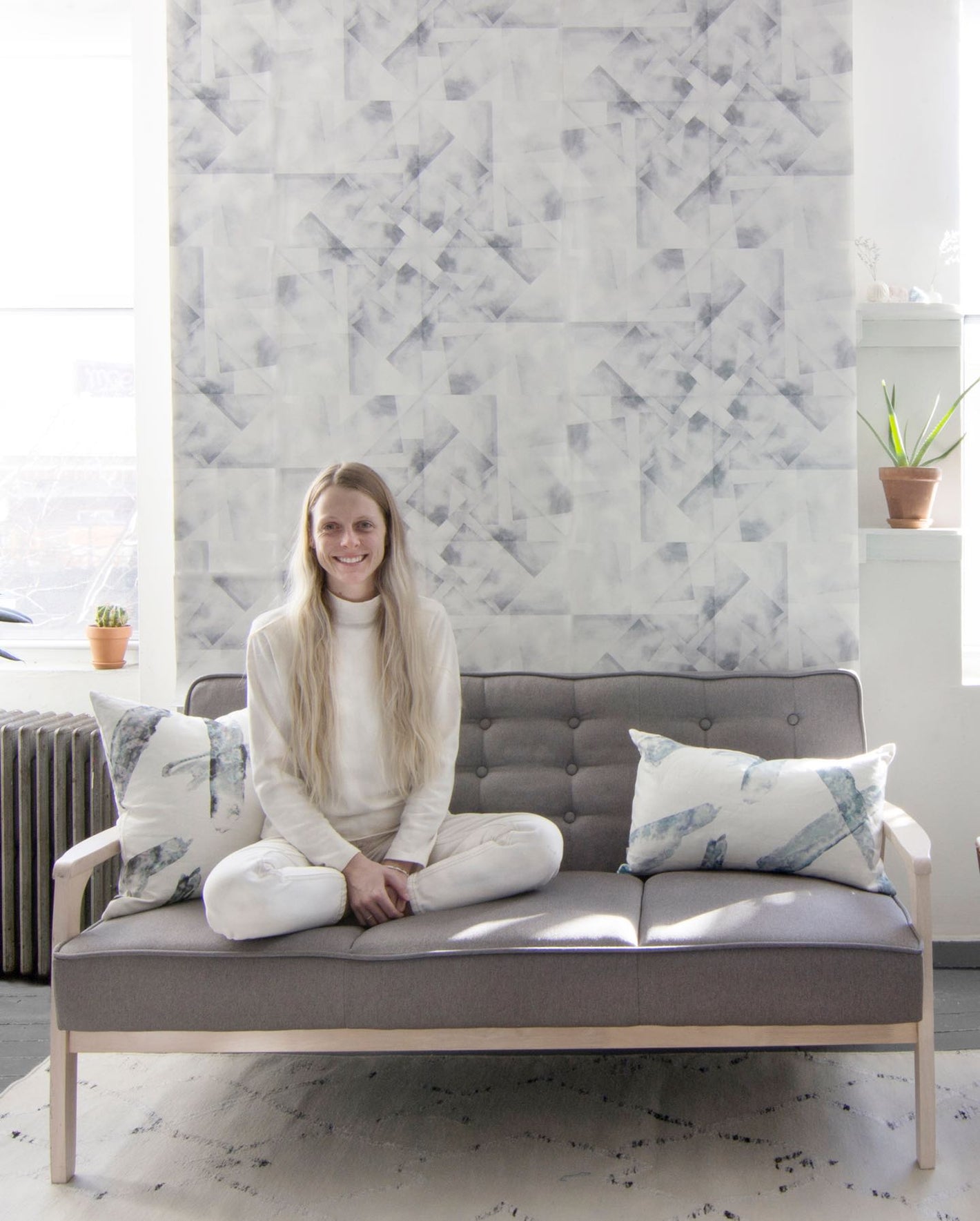 A woman sitting on a couch in front of a wall