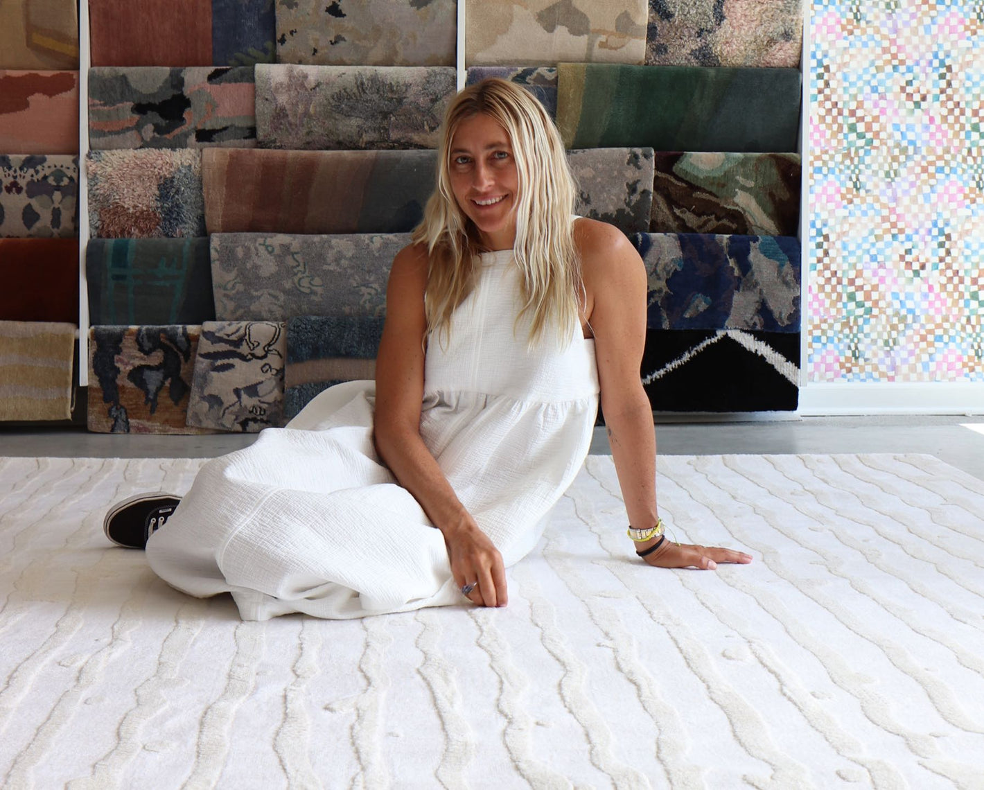 A woman in a white dress sitting on a white rug