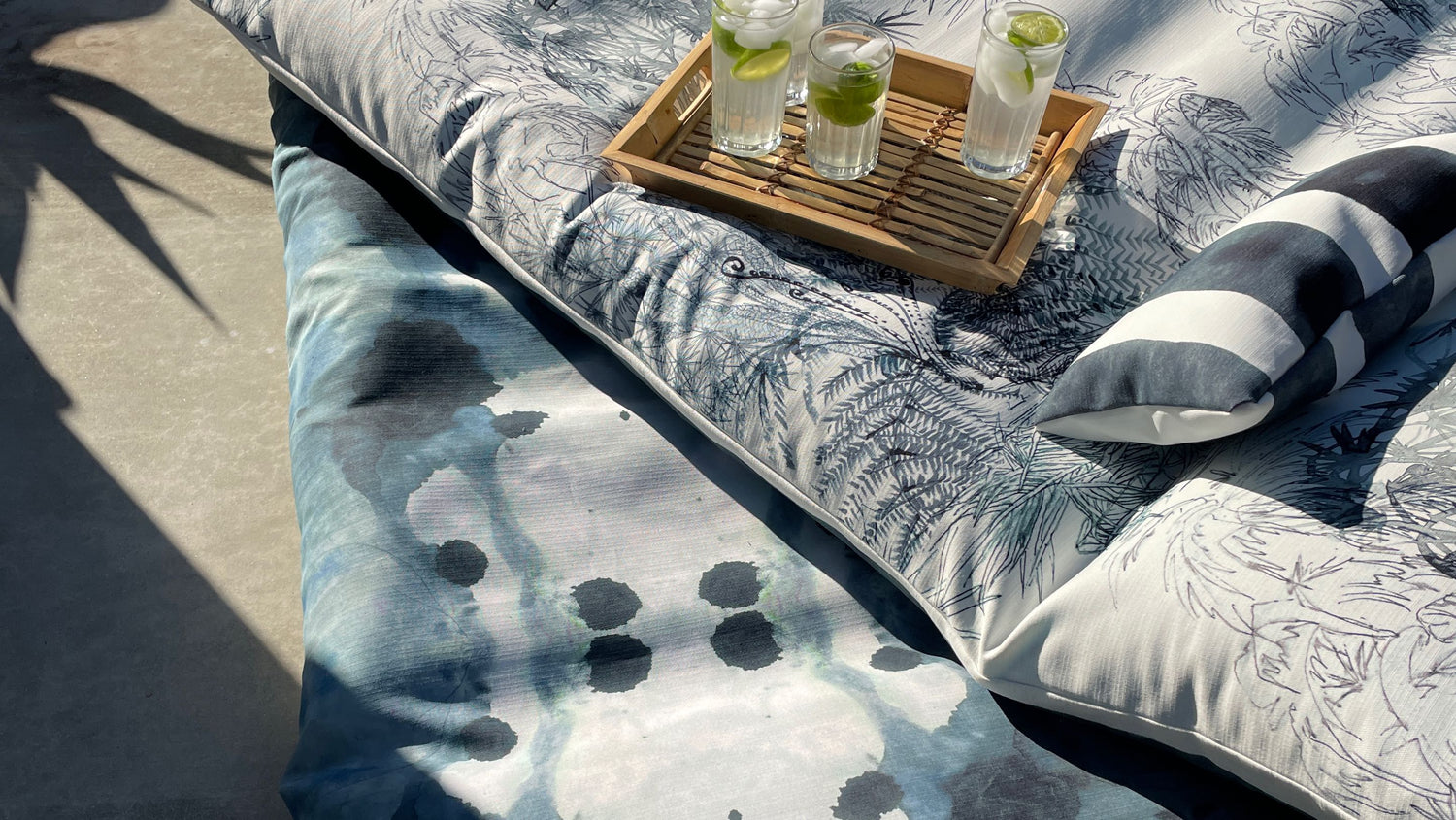 A bed with pillows and a tray of drinks