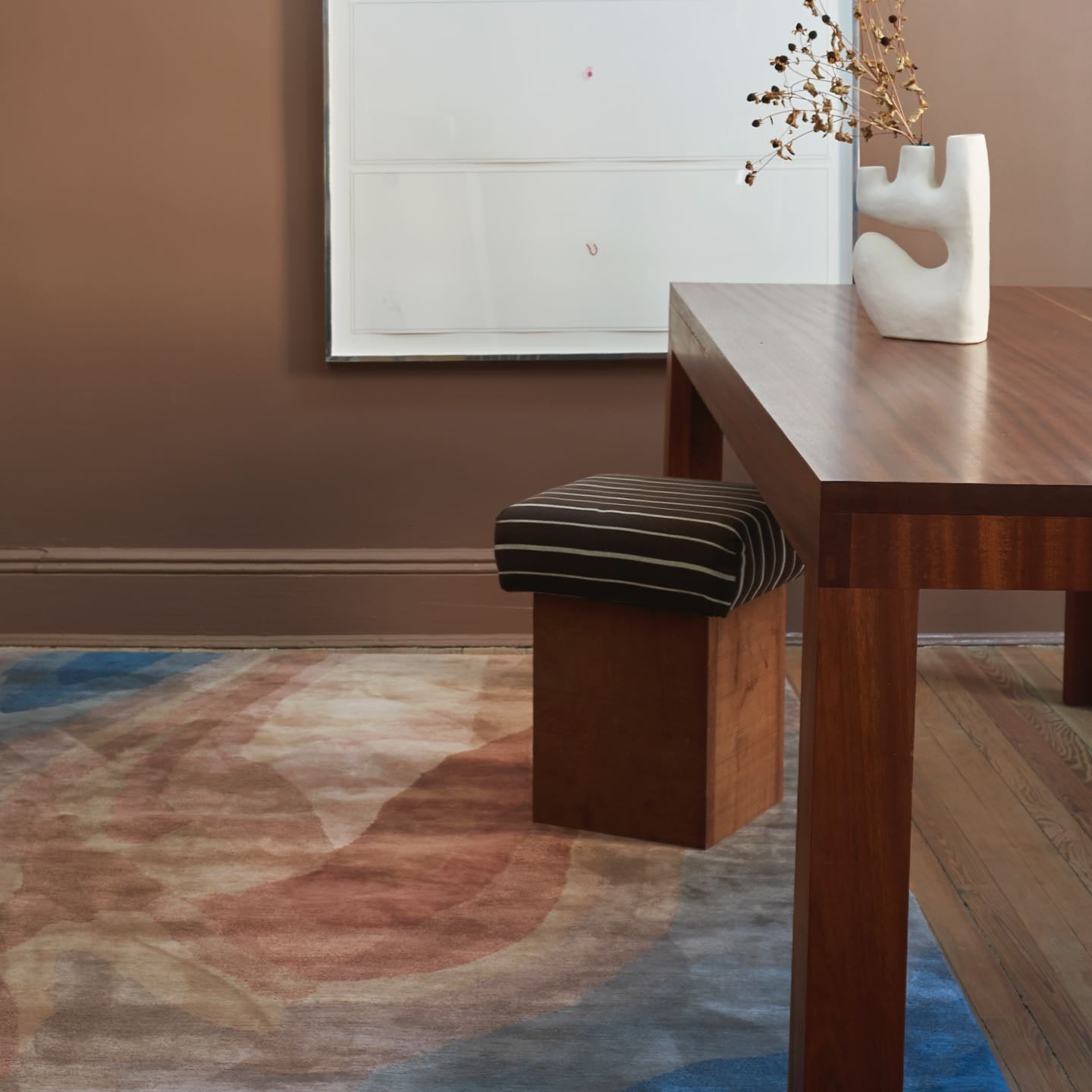 A room with a wooden table, chairs, and a rug