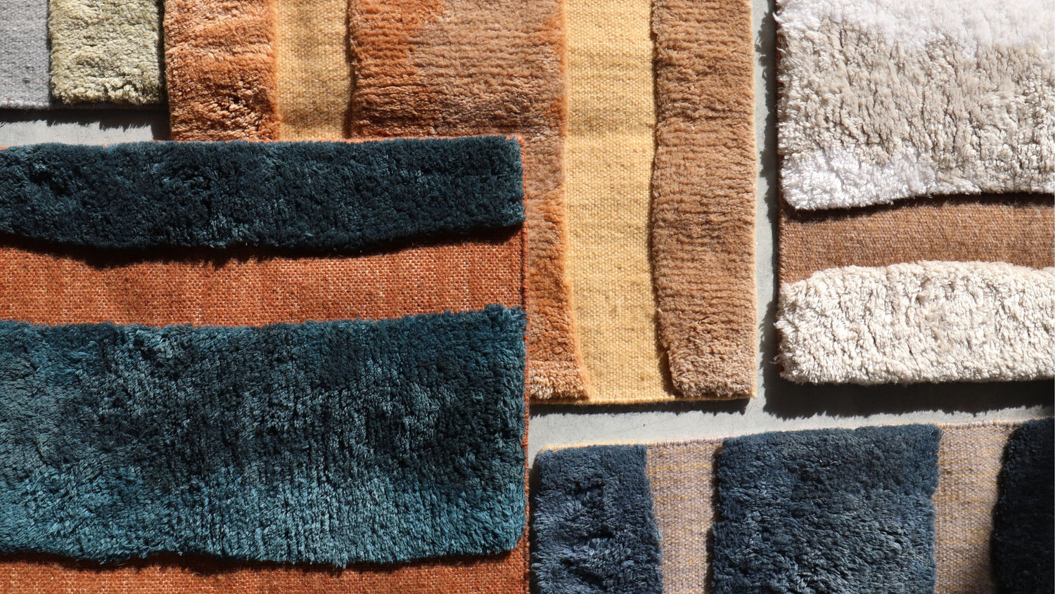 A collection of different colored rugs on a wall