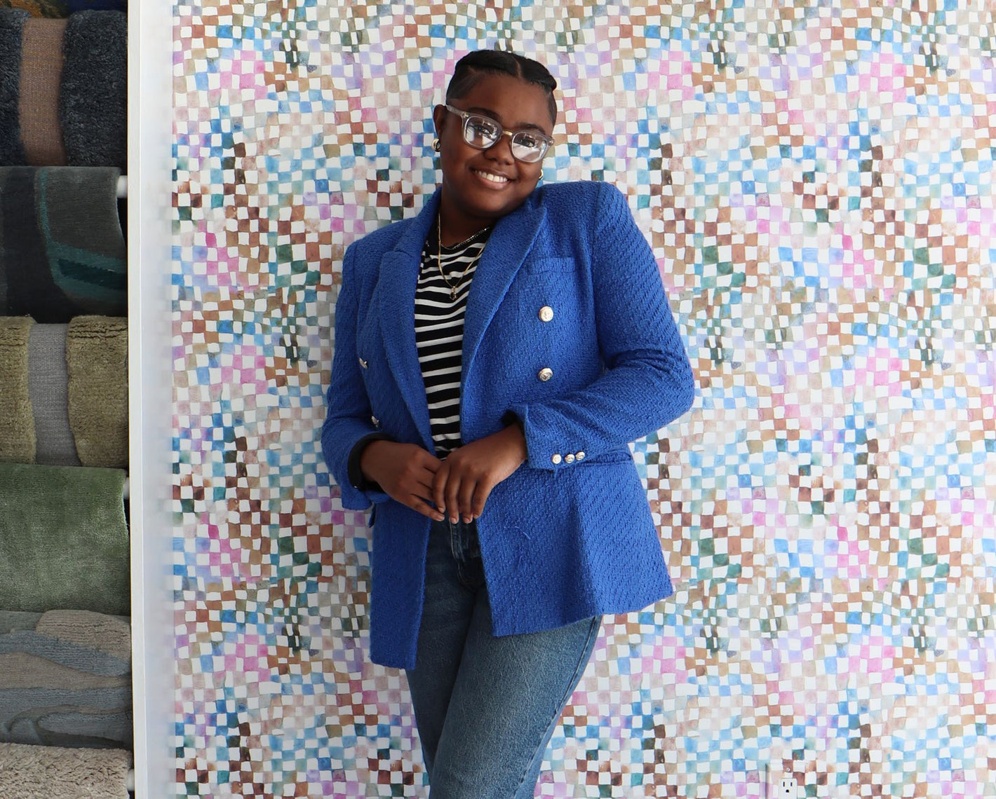 A woman in a blue blazer standing in front of a wall