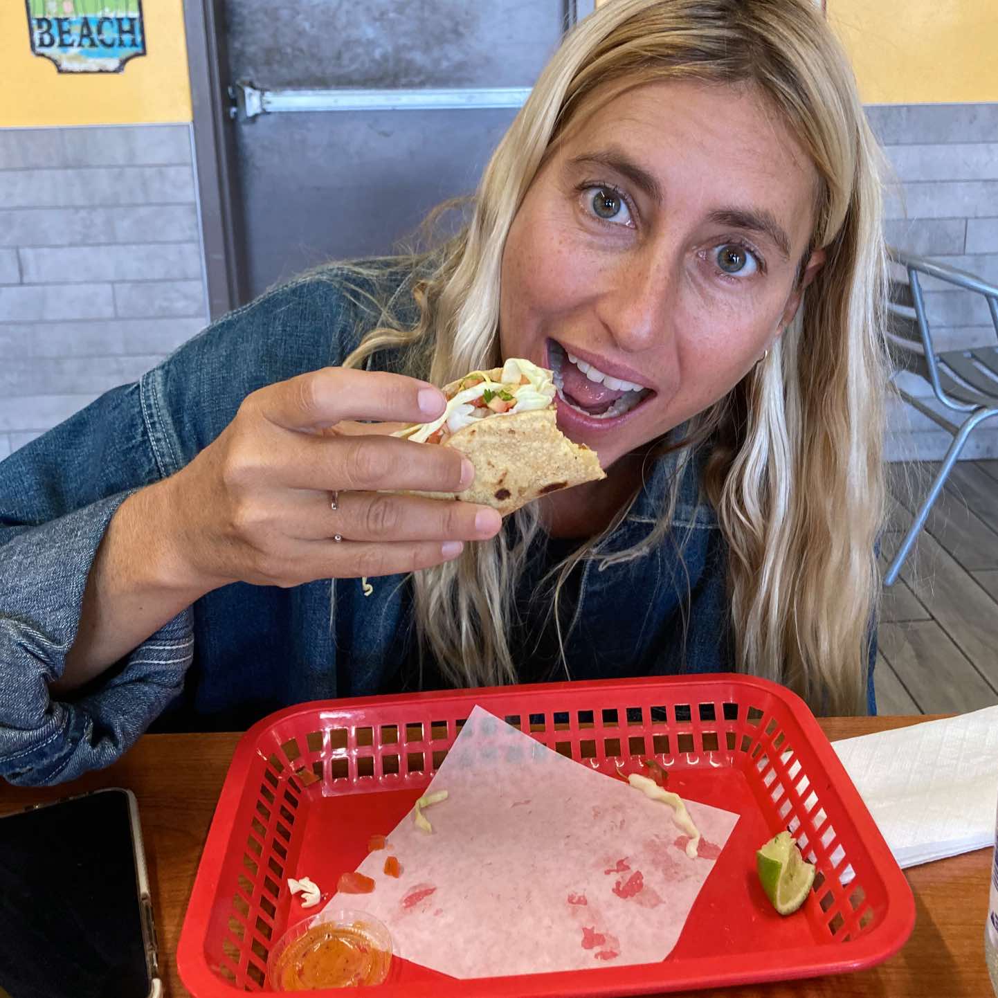 A woman enjoying a taco at a restaurant