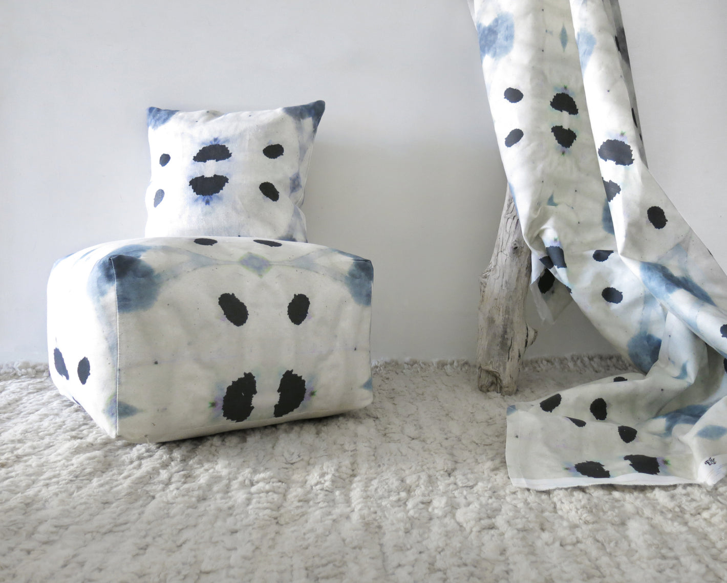 A white polka dot pillow on a rug