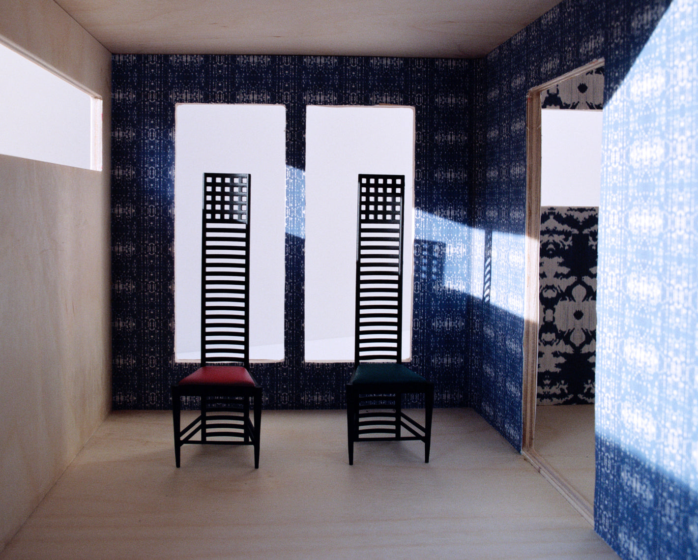 Two chairs in a room with blue wallpaper