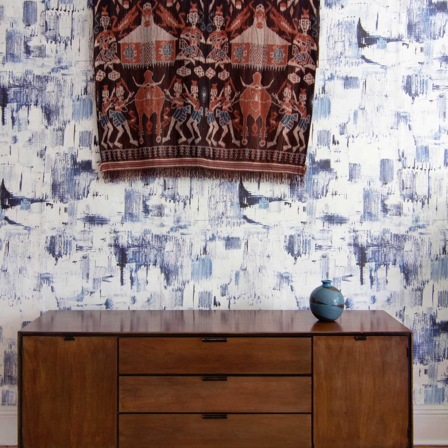 A dresser against a blue wallpaper