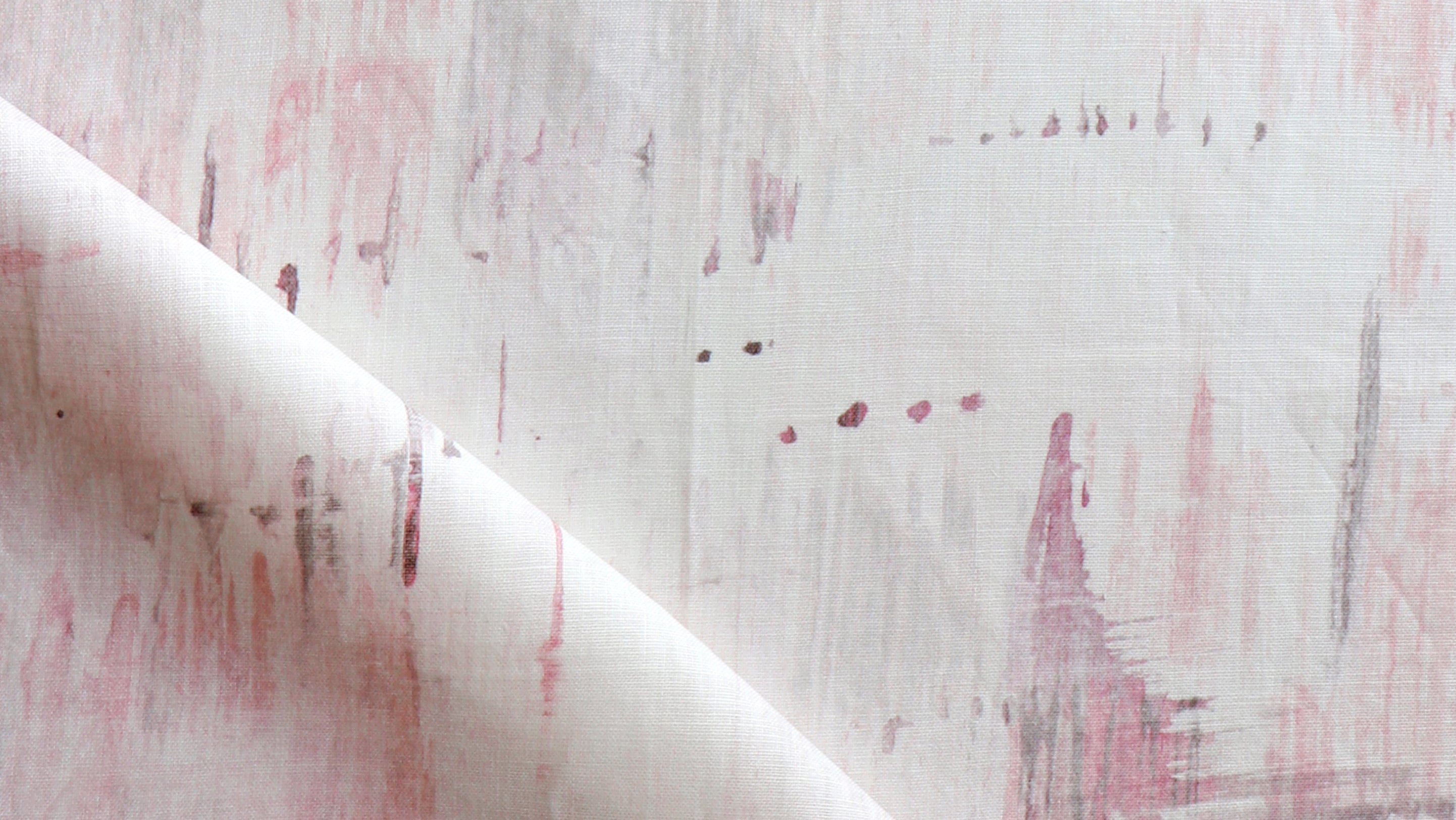 A close up of a pink and white painting on fabric