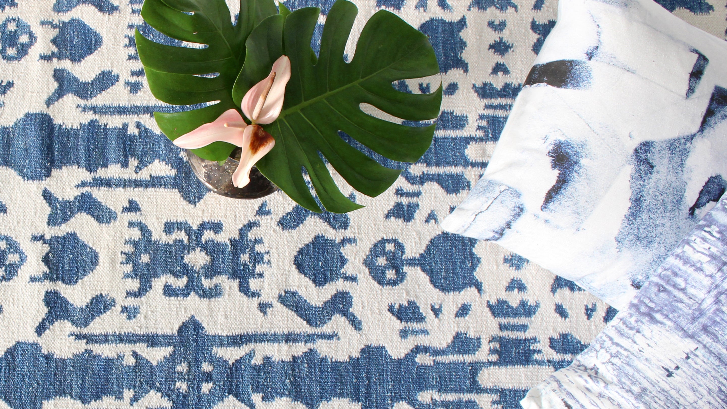 A blue and white rug with a plant