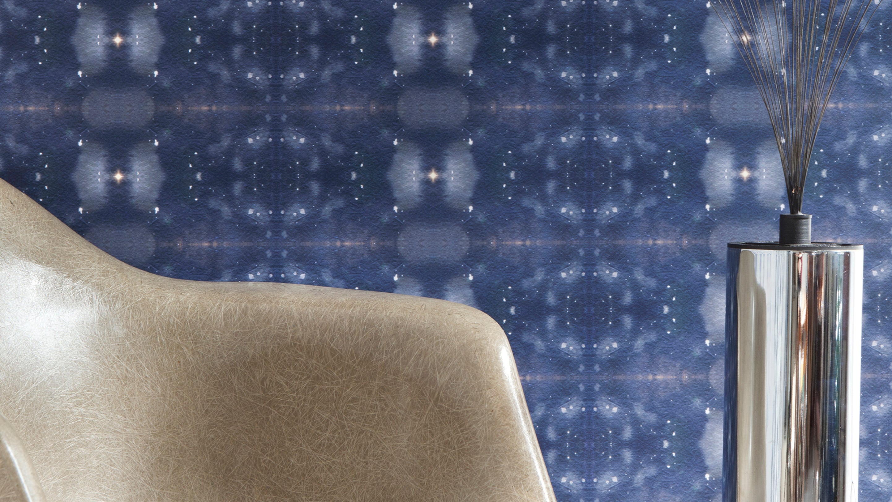 A chair in front of a blue wallpaper