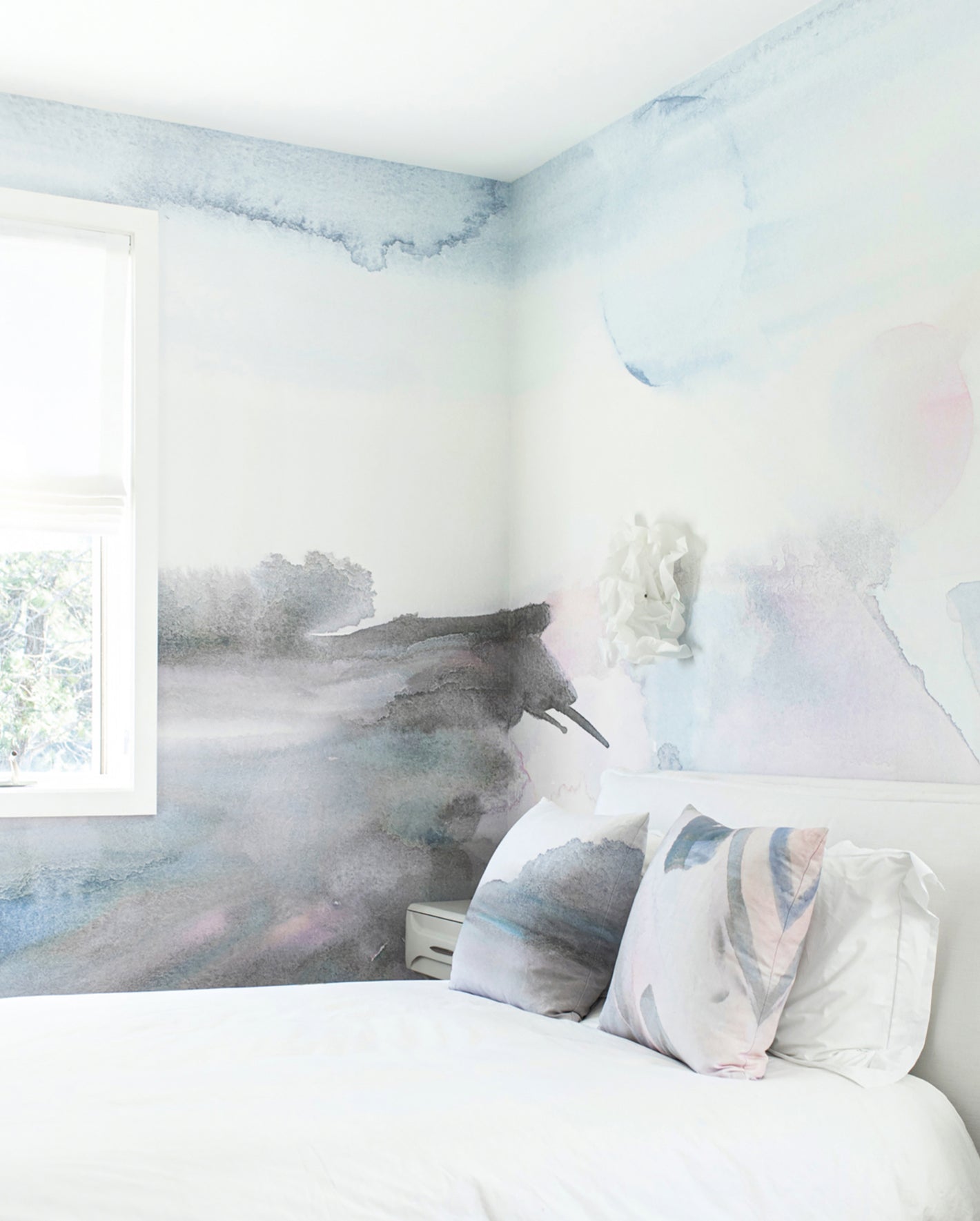 A white bed in a room with blue and wall