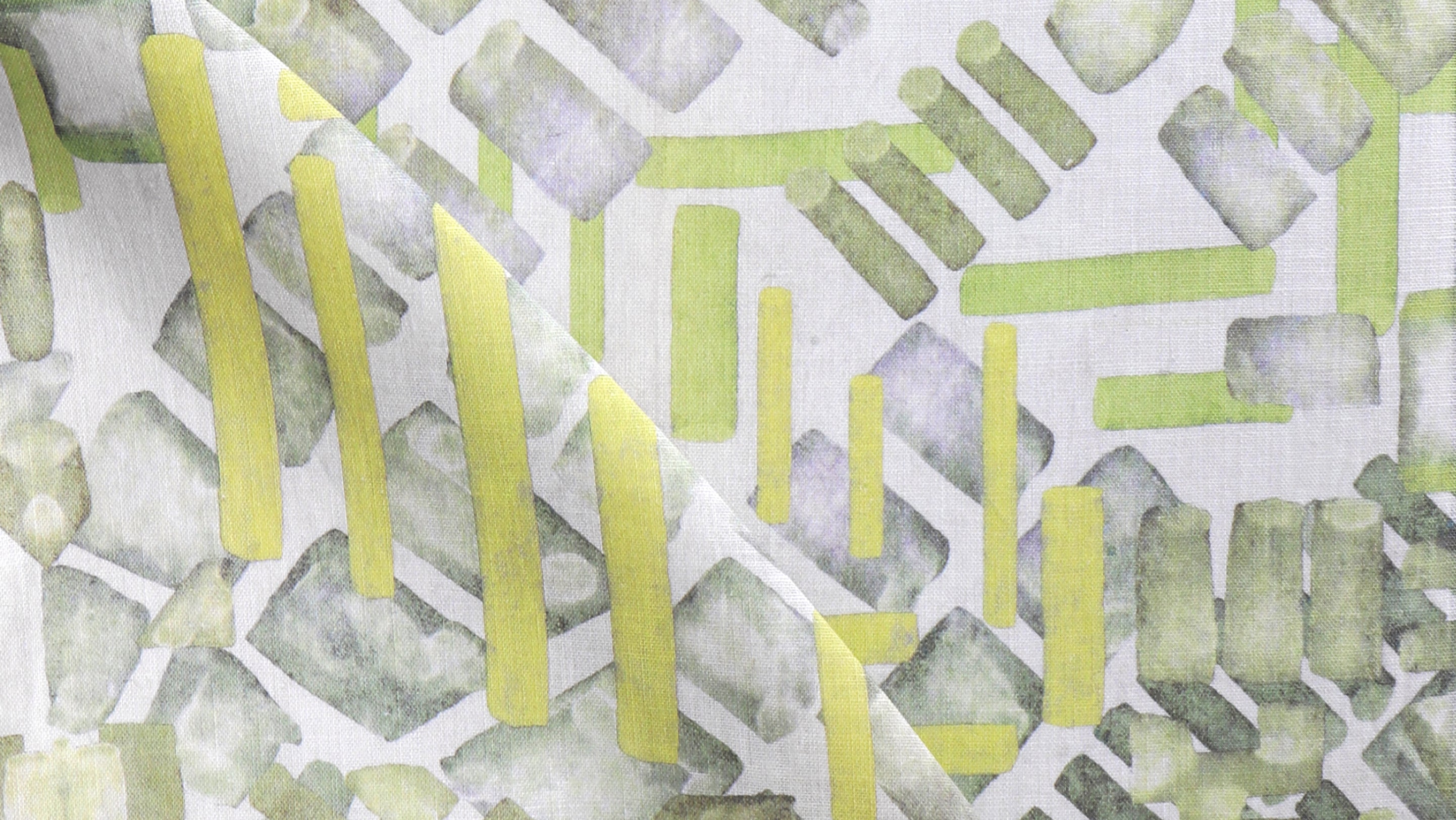 A close up of a green and yellow abstract pattern on white fabric