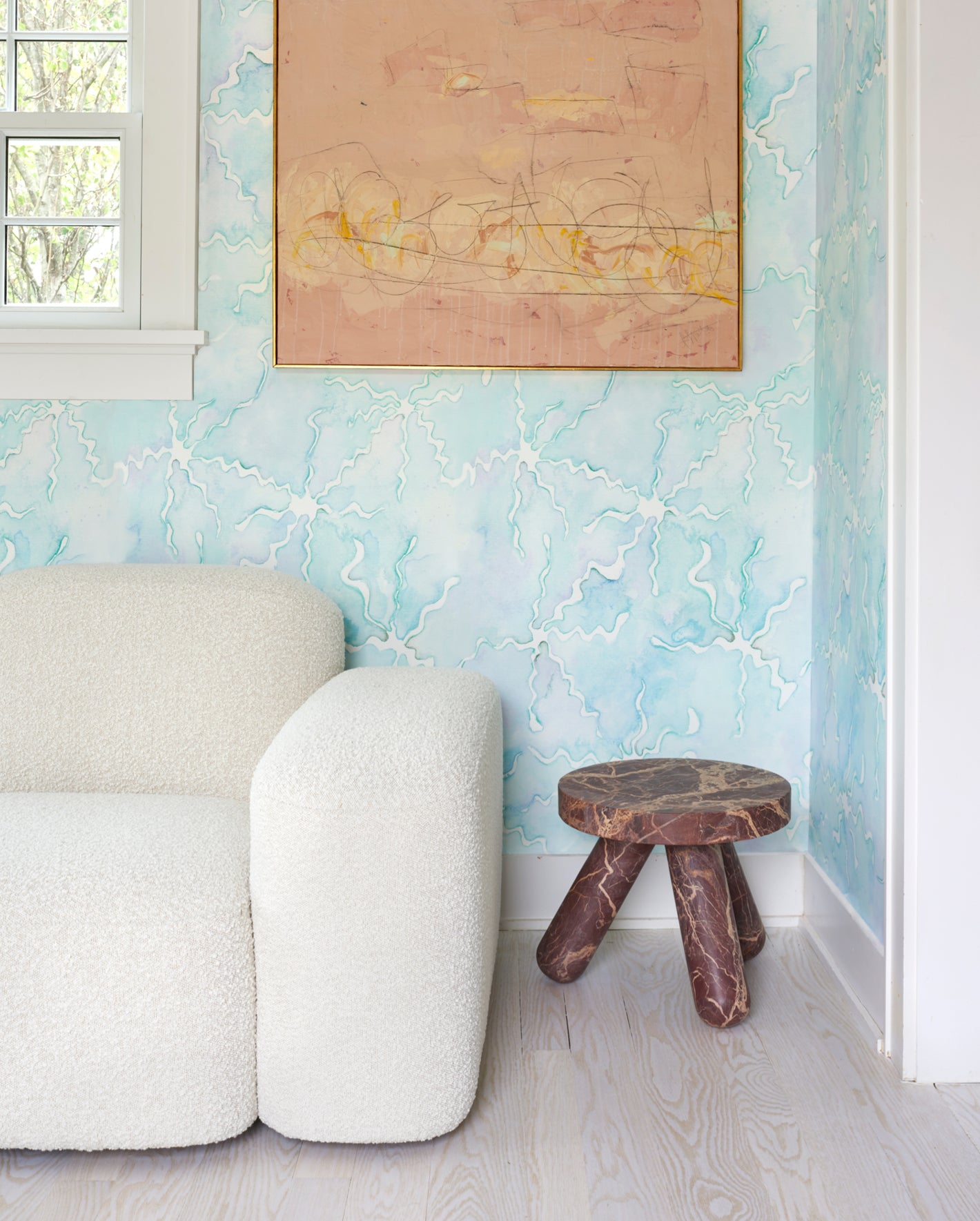 A living room with blue wallpaper and wooden stool