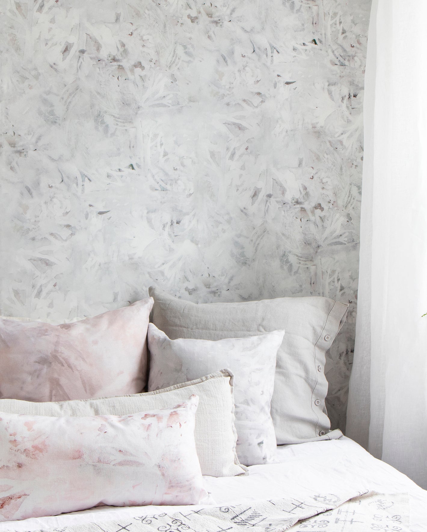 A bedroom with a white bed and pink pillows