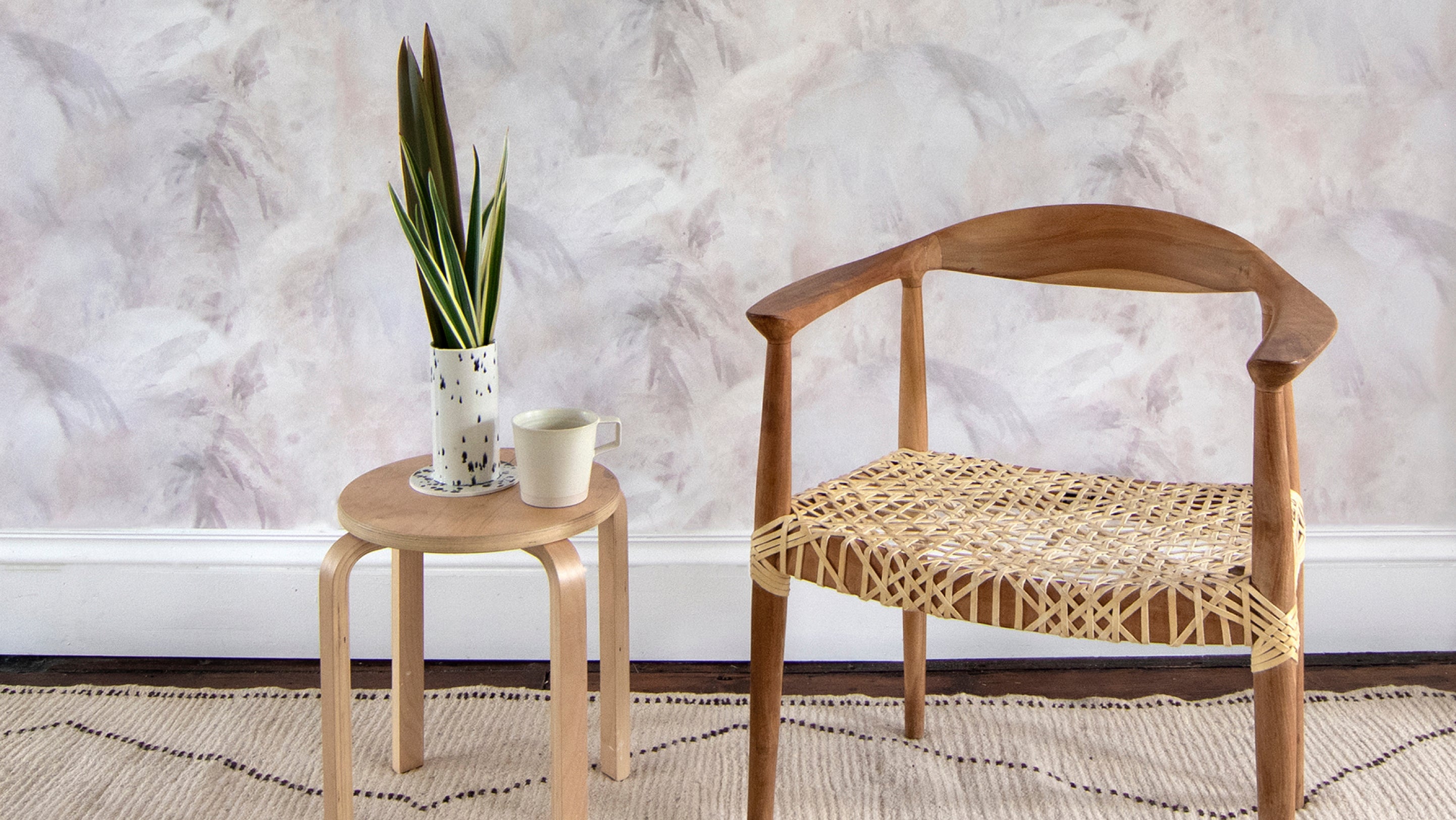 A chair and a table in front of wallpaper