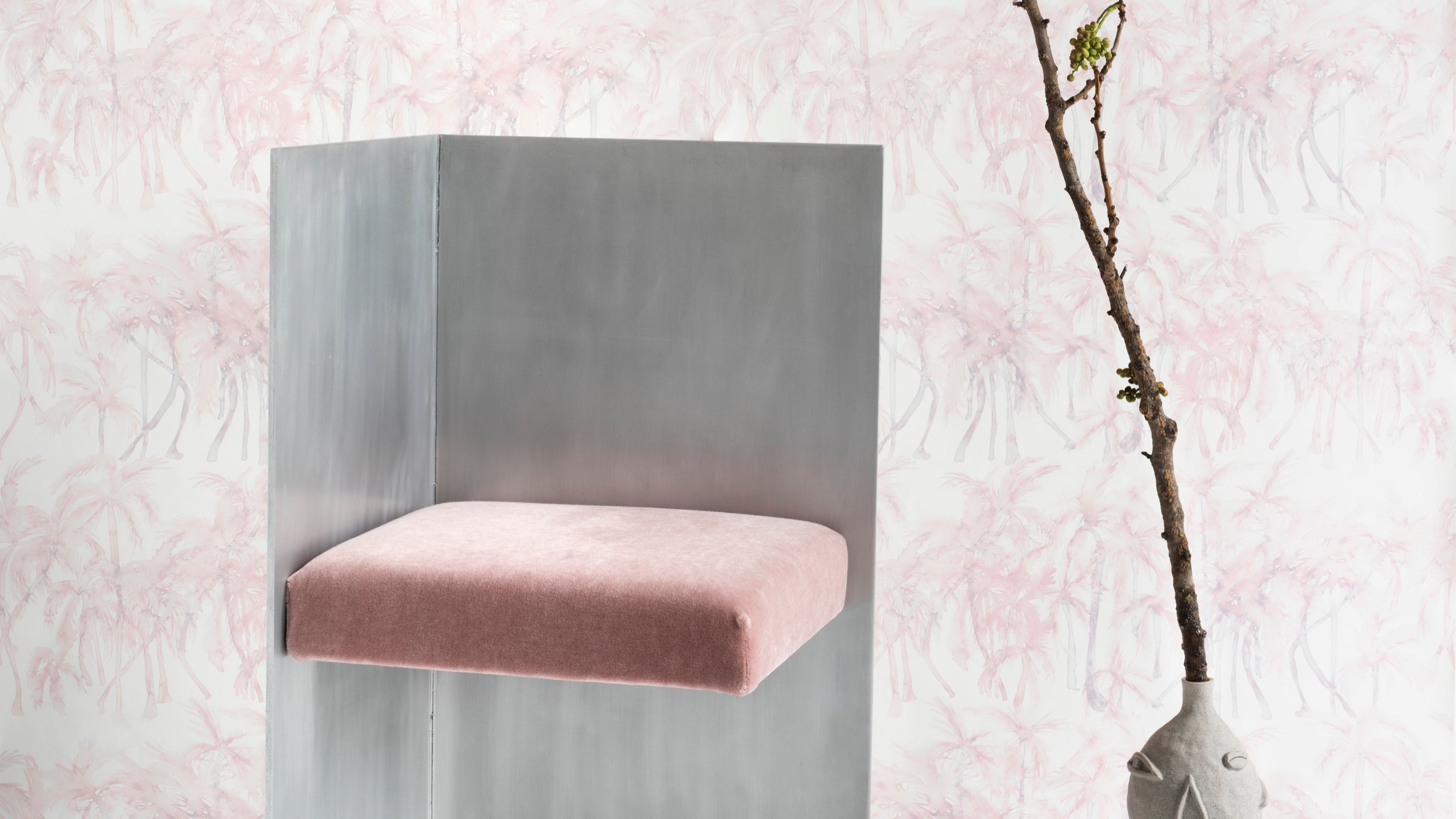 A chair with a pink cushion in front of a wall