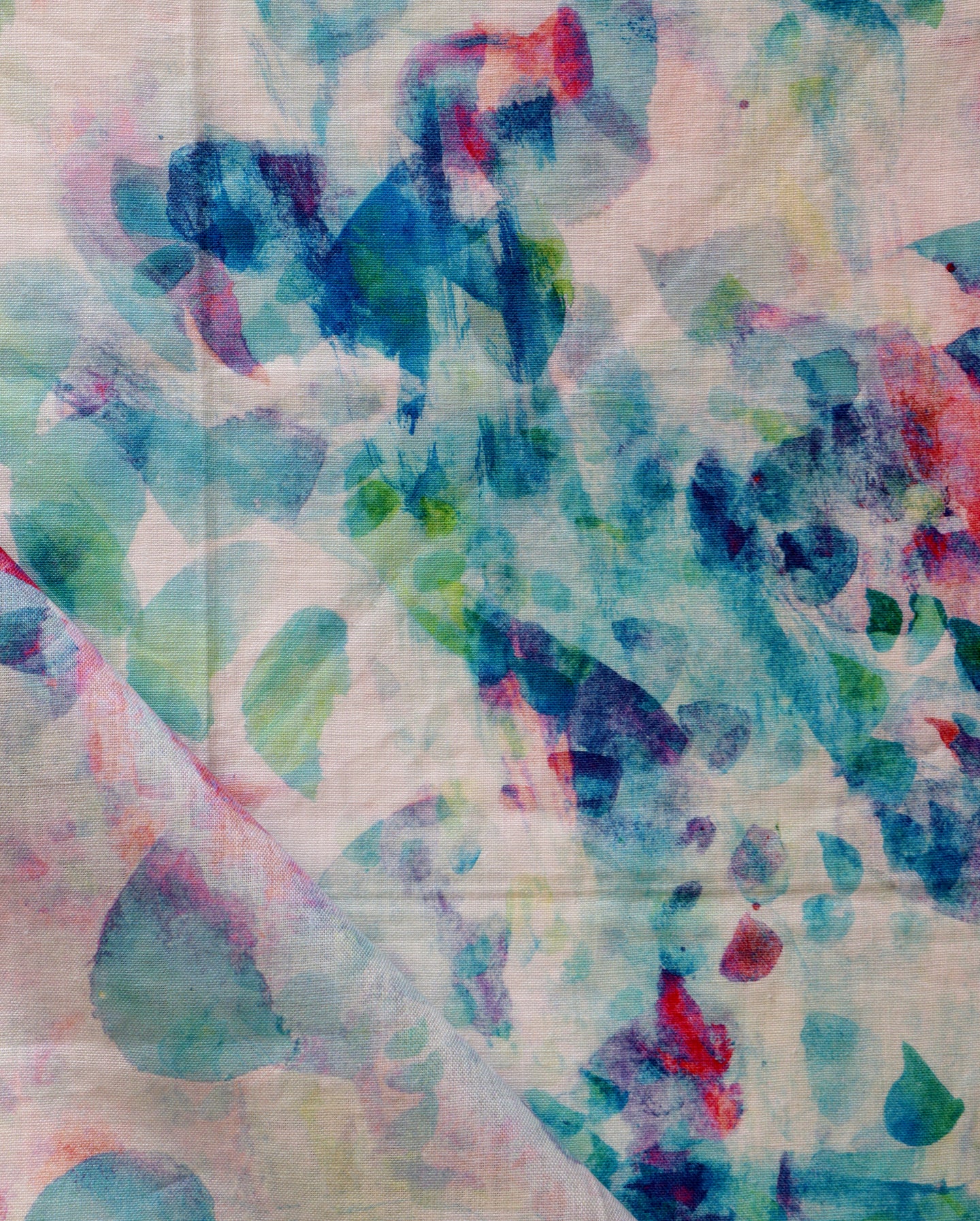 A fabric with blue, pink, and green paint on it