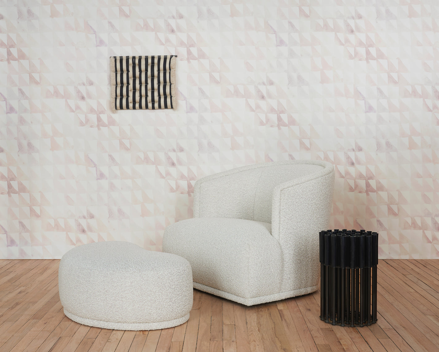 A white chair in front of a wall with a geometric pattern