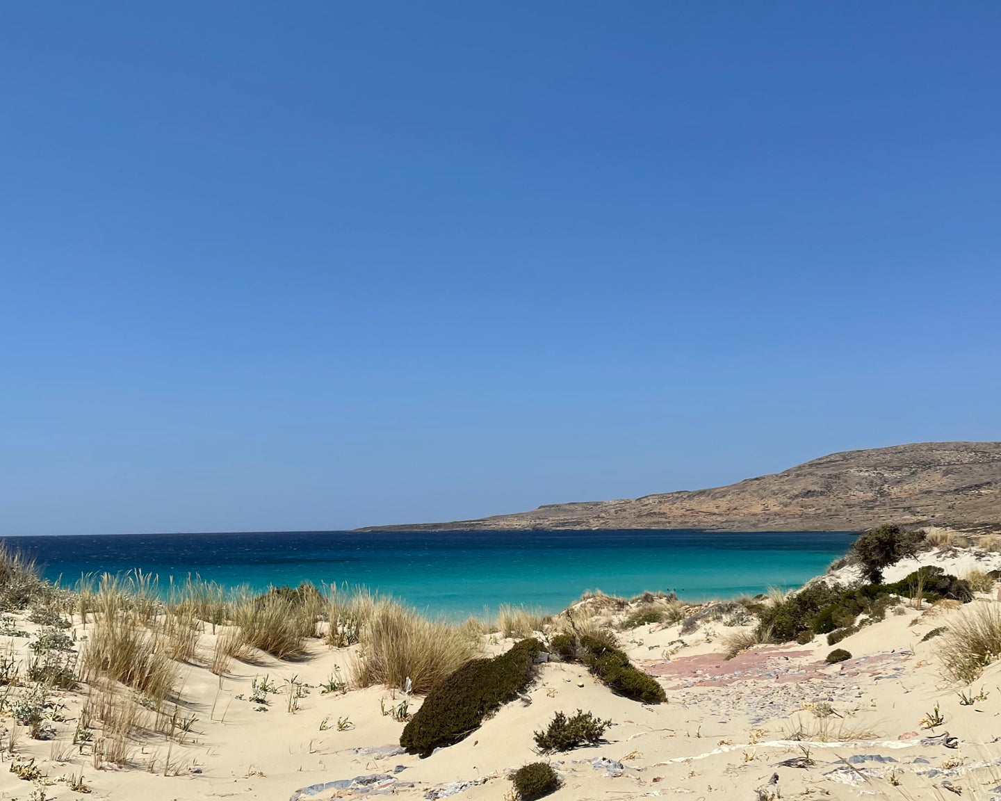 A beach with blue water and sand