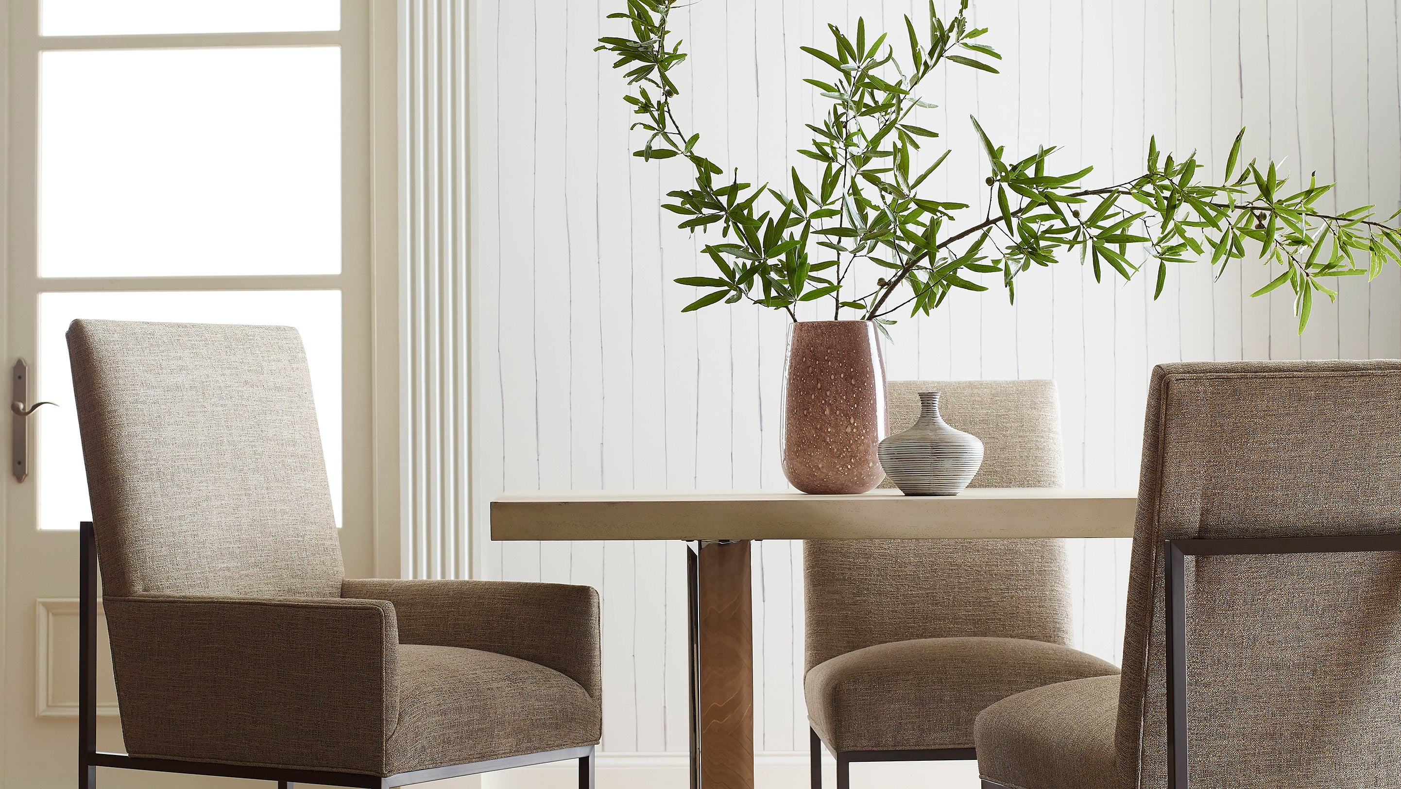 Our Pen Stripe Wallpaper in Ink with its traditional pinstripe design in black and white is installed in a dining room.