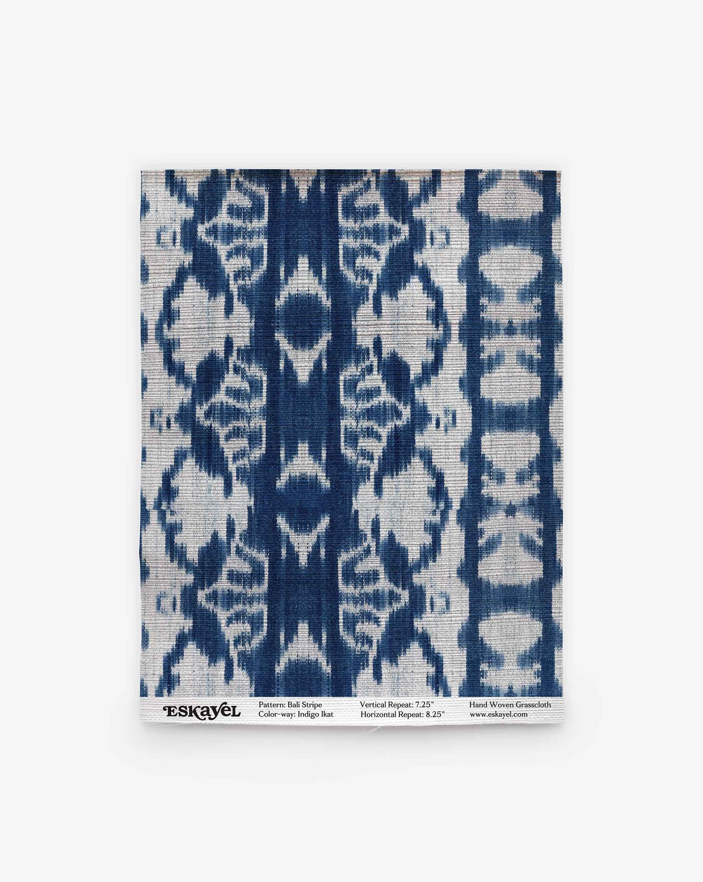 A square swatch of Bali Stripe Grasscloth in the Indigo Ikat design, featuring a bold, symmetrical blue and white pattern with labeled details along the bottom edge.