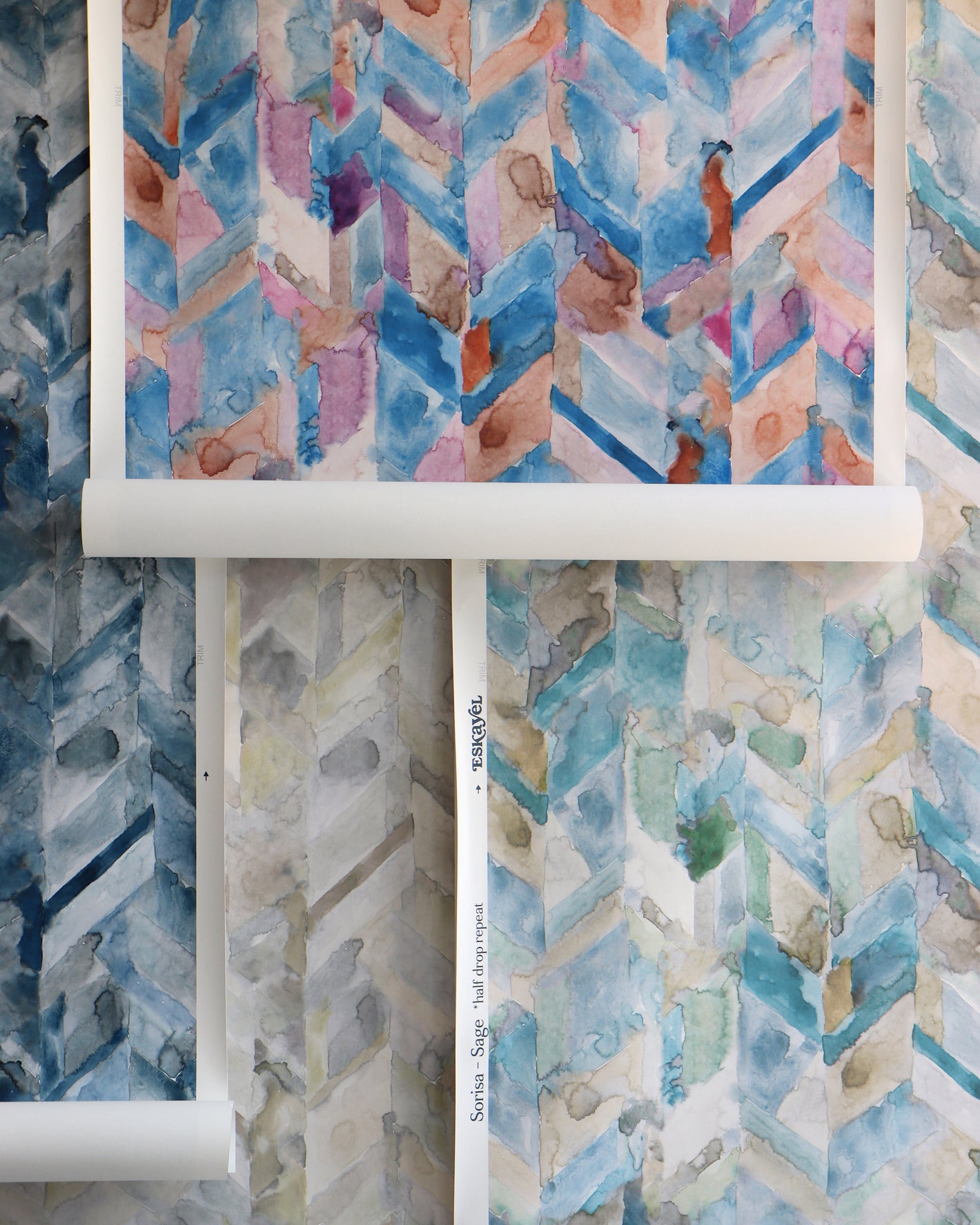 Three rolls of wallpaper with watercolor designs