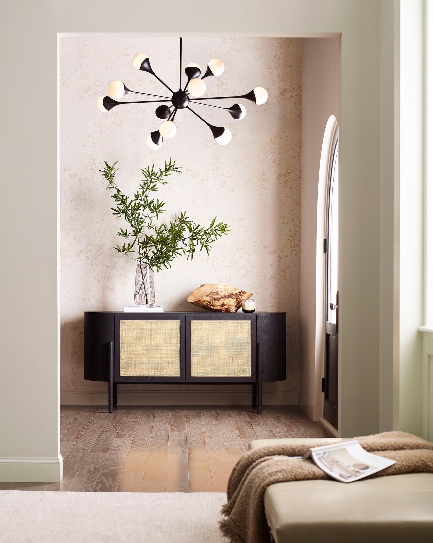 A hallway with a black console and a playful Bandanarama Wallpaper flax featuring a lamp