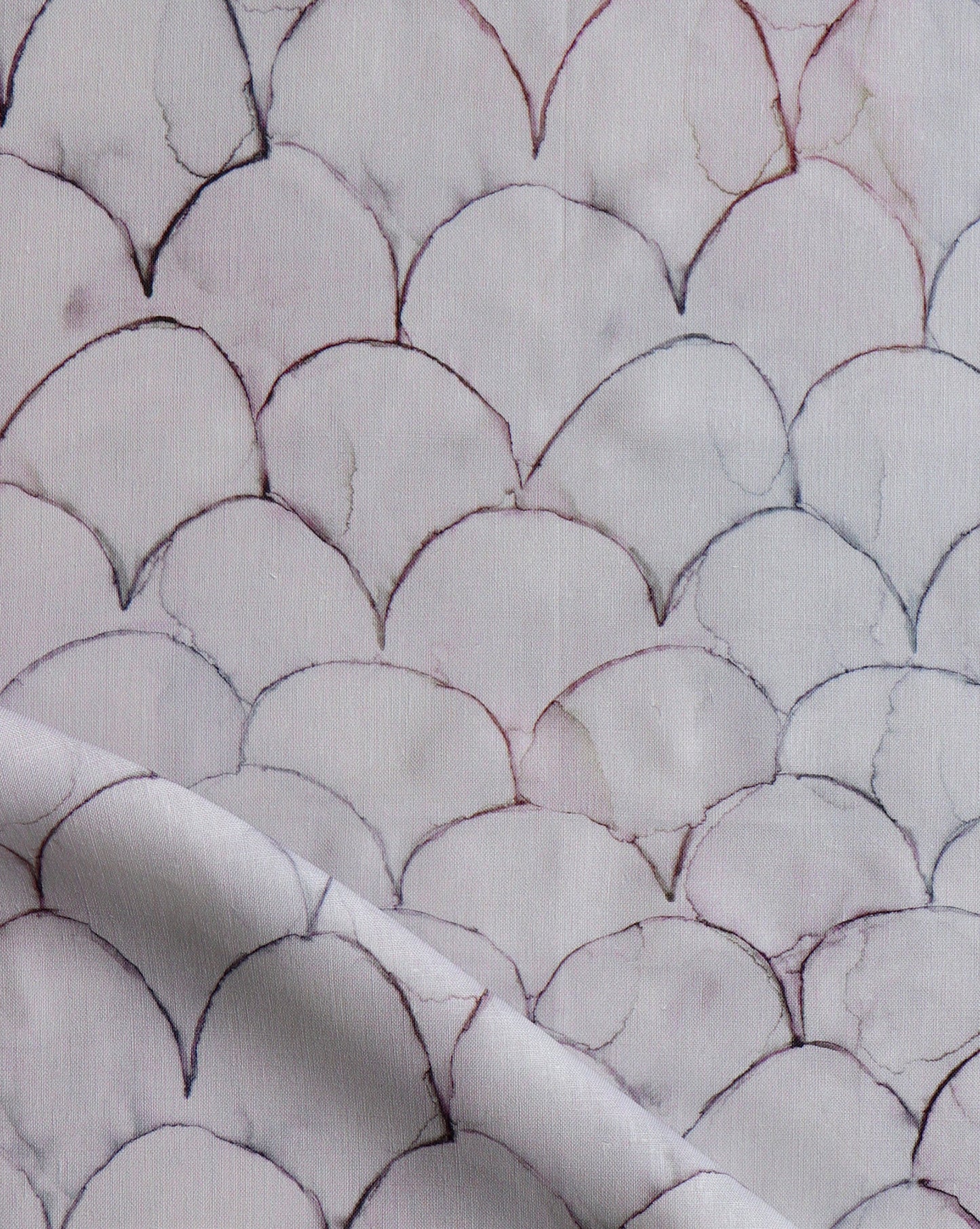 Baby Scallops fabric in Pomegranate introduces tones from mauve to blue into a geometric pattern of overlapping curves