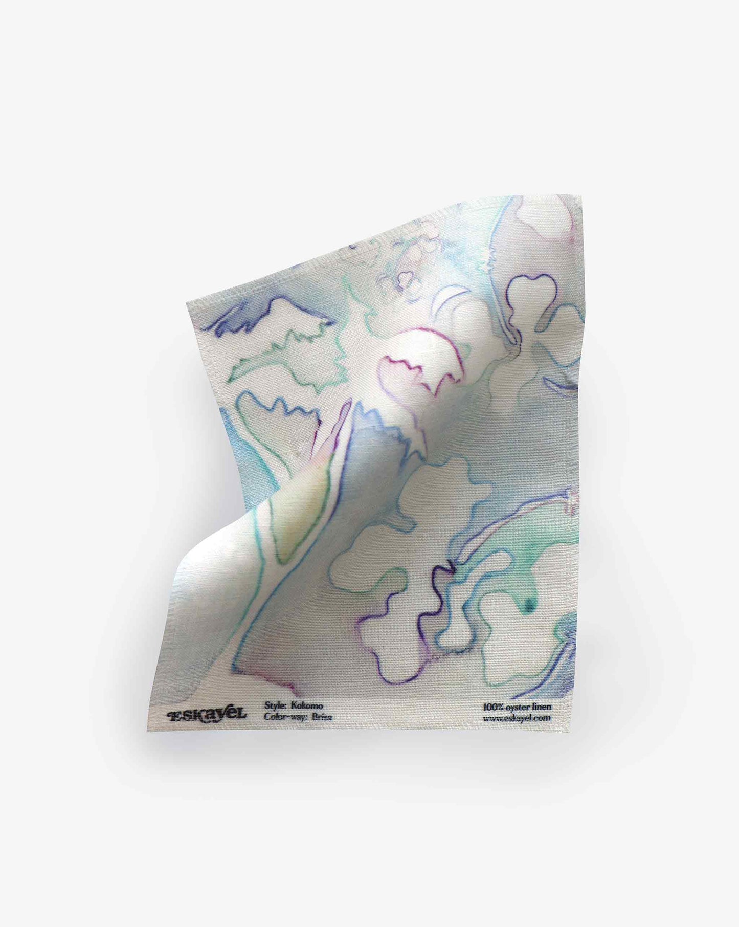 A single, crumpled Kokomo Fabric Sample||Brisa with a watercolor-style floral design in pastel colors on a white background. Text on the napkin indicates it's made from 100% organic cotton. Perfect to order as a sample to experience its texture and quality firsthand.
