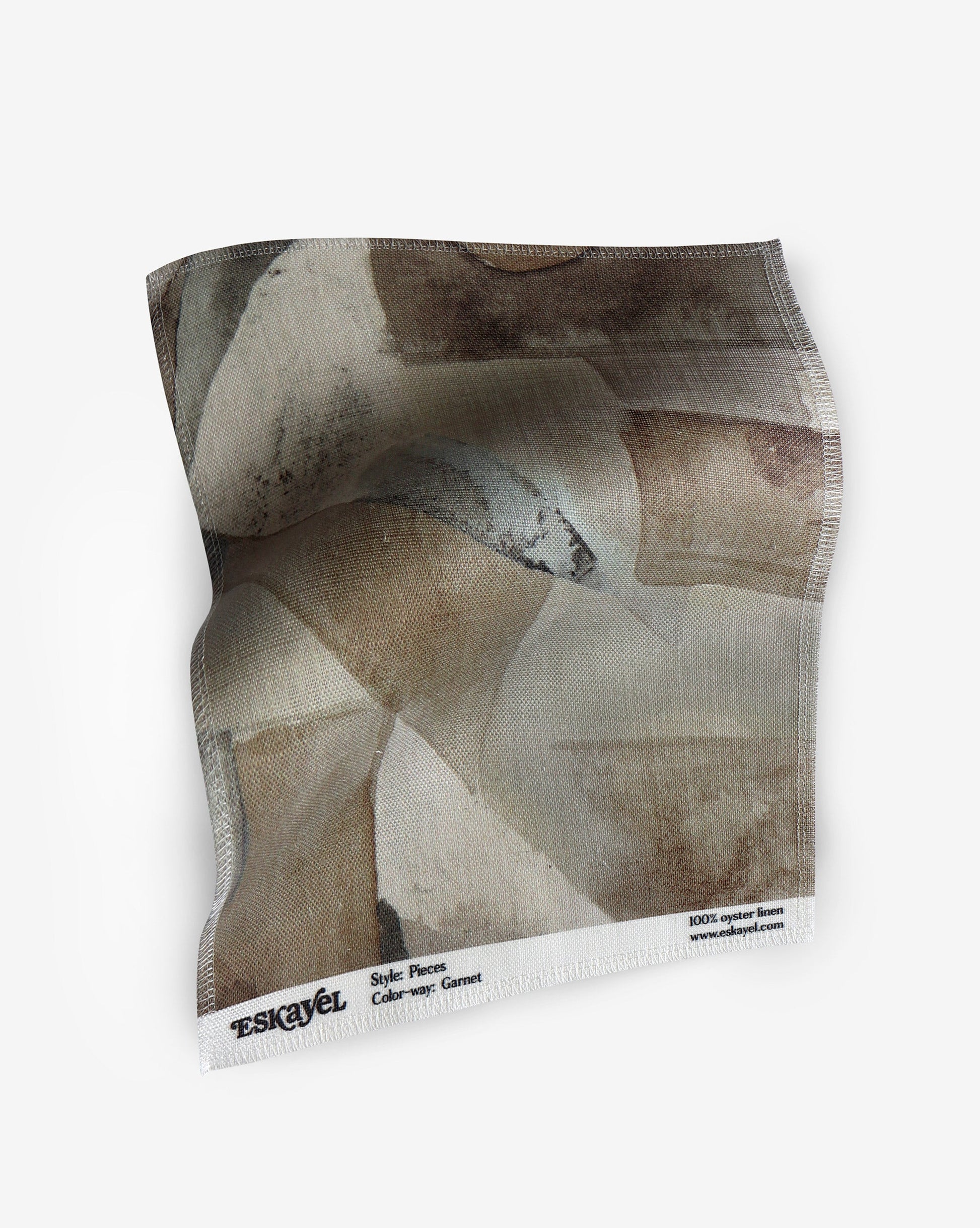 A fabric with our pieces pattern in garnet featuring a color blocked design of puzzle pieces in earthy brown shades.