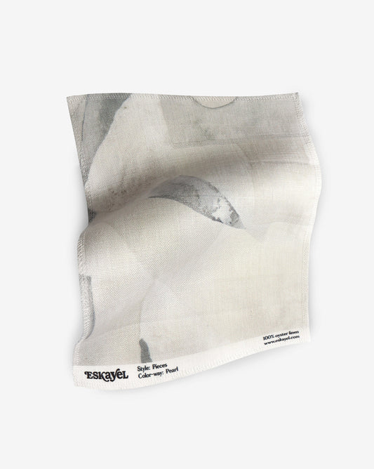 A fabric with our pieces pattern in pearl featuring a color blocked design of puzzle pieces in shades of yellow.