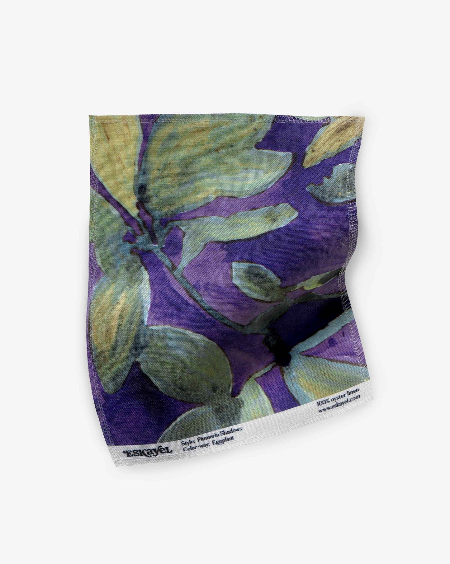 A swatch of Eskayel’s Plumeria Shadows fabric pattern in Eggplant, a colorway of purple with green tones.