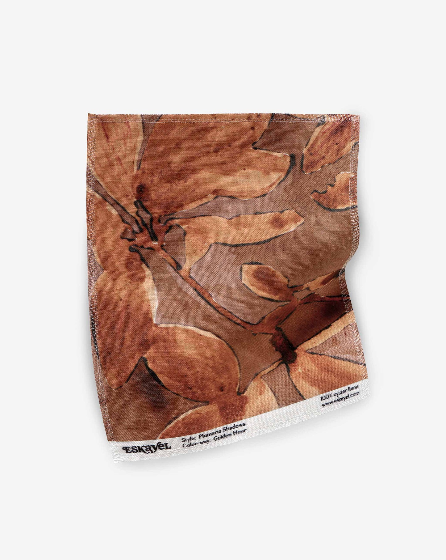 A swatch of Eskayel’s Plumeria Shadows fabric pattern in Golden Hour, a colorway of rich brown and gold tones.