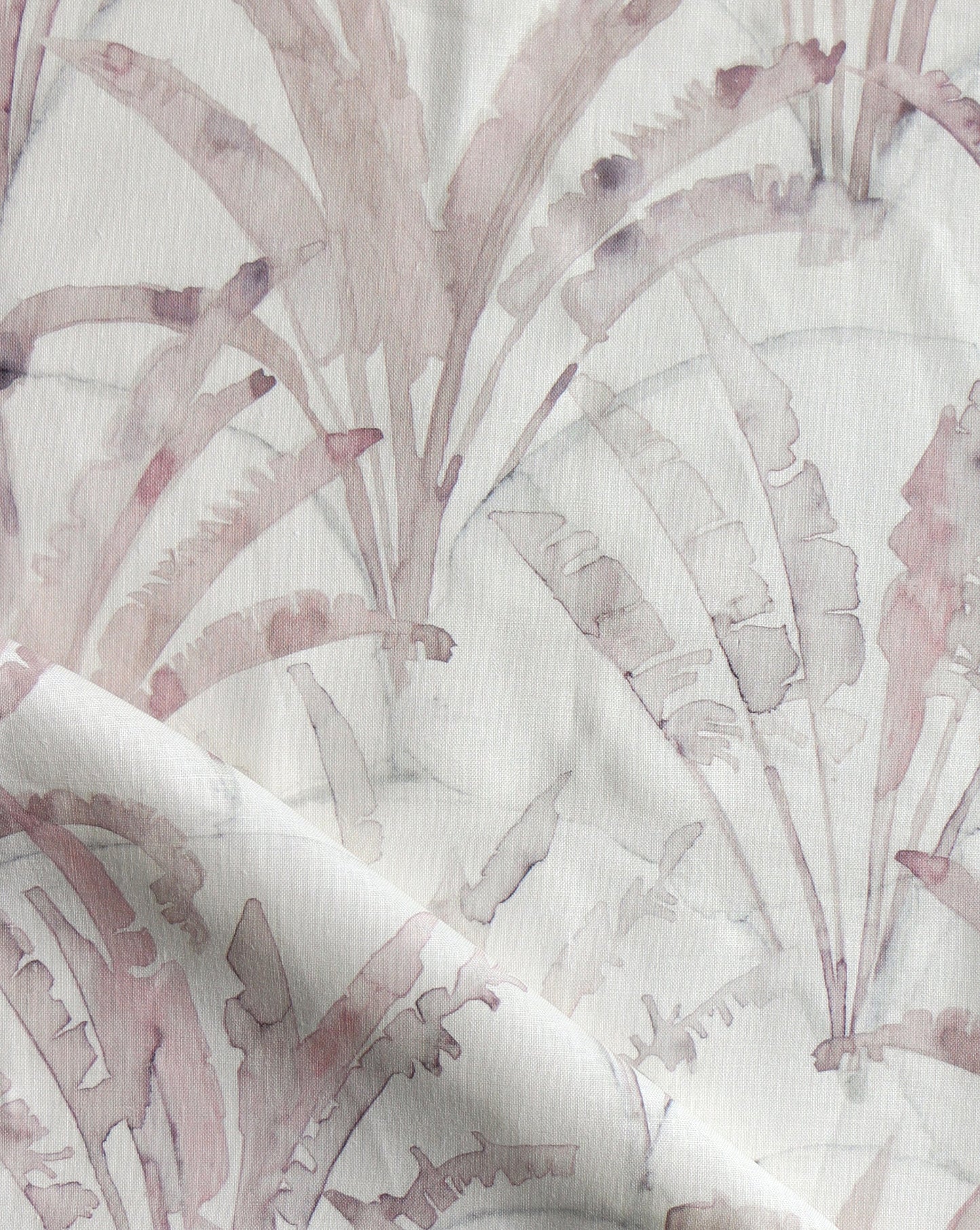 In Travelers Palm, fan-like trees sit on a scallop background The warm Shell colorway incorporates dusty rose hues on beige