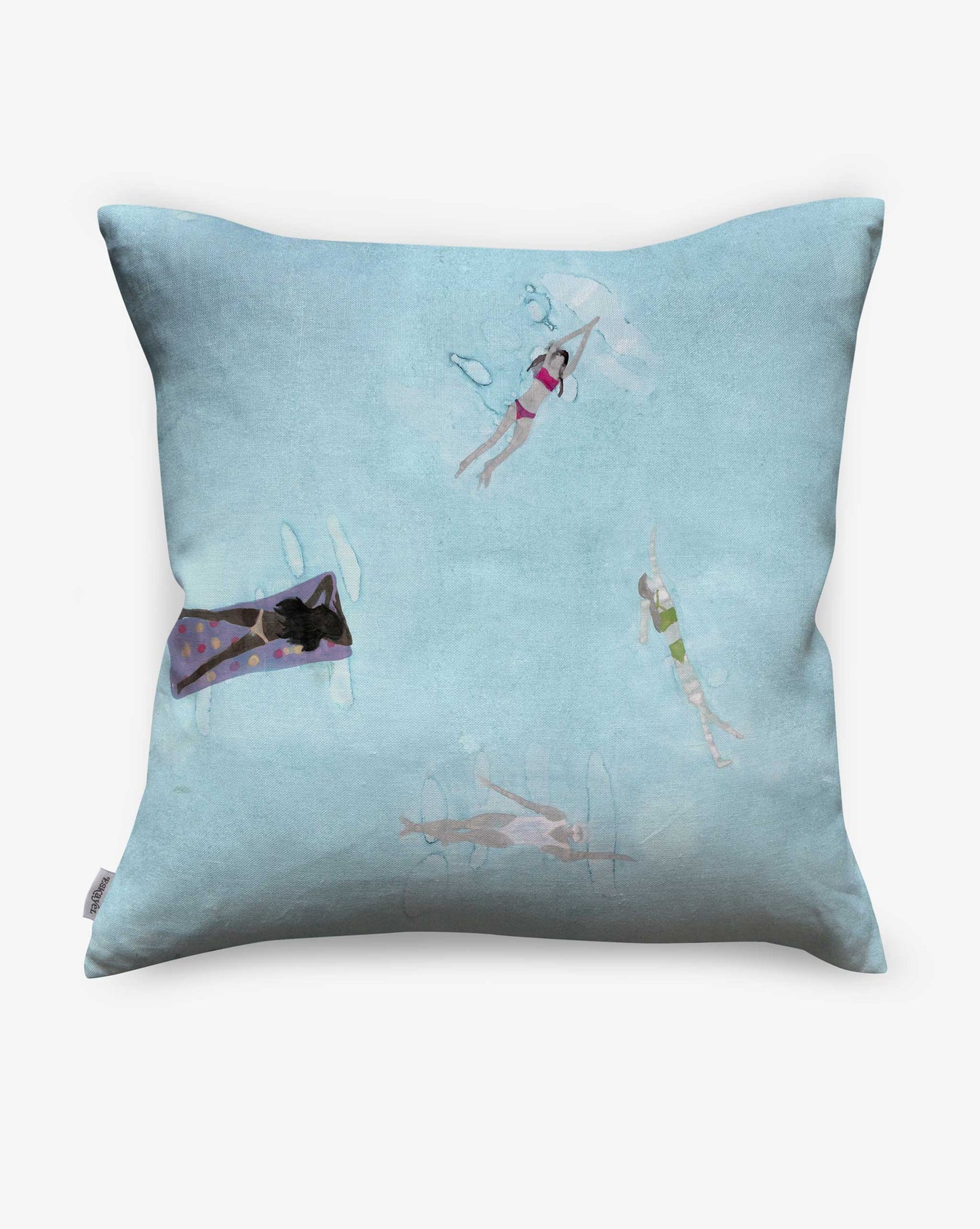 The Swim Pillow in Sea features a light blue front cover with a playful print of four swimmers in a pool—perfect for adding beach house charm.