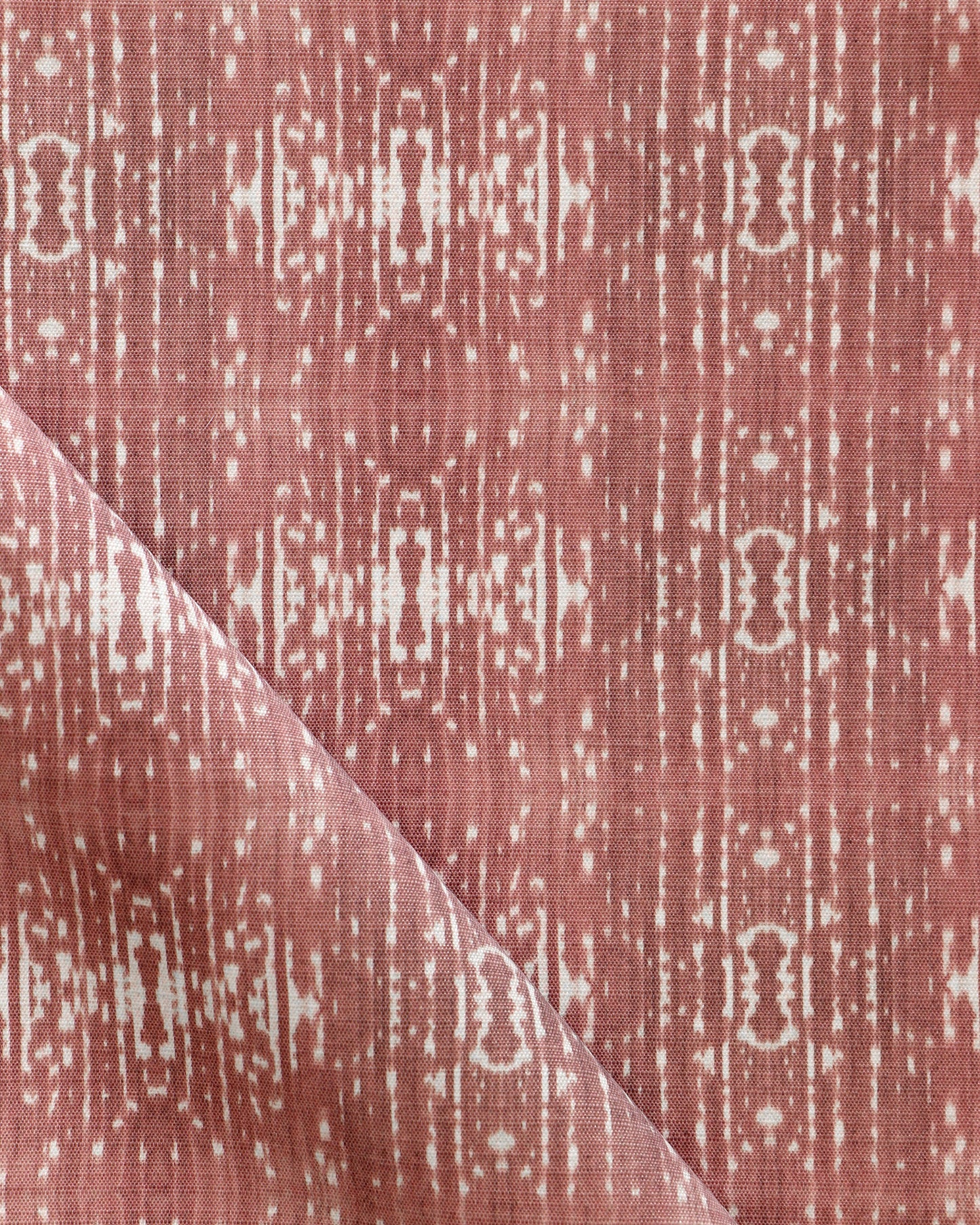 A pink and white Omaha Kinship Performance Fabric in the Morinda Ikat colorway with a geometric pattern