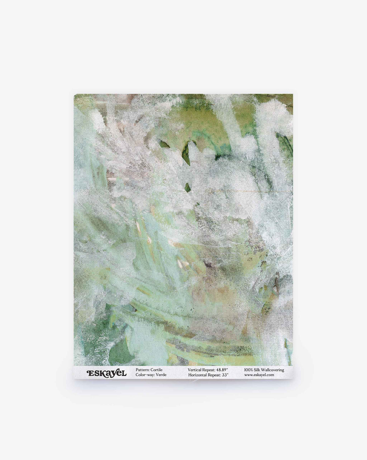 A sample of Cortile Silk Wallcovering||Verde, featuring an abstract green and white watercolor pattern, is displayed upright on a white surface and labeled “ESKAYEL” at the bottom.