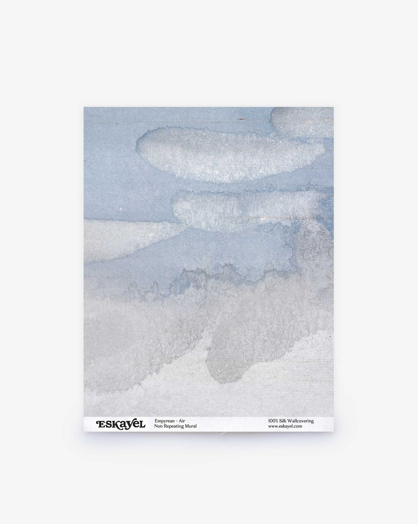 The Empyrean Silk Mural wallcovering sample in Air is an abstract watercolor painting, reminiscent of Maldivian sunrises and sunsets, features shades of blue and gray with cloud-like formations.