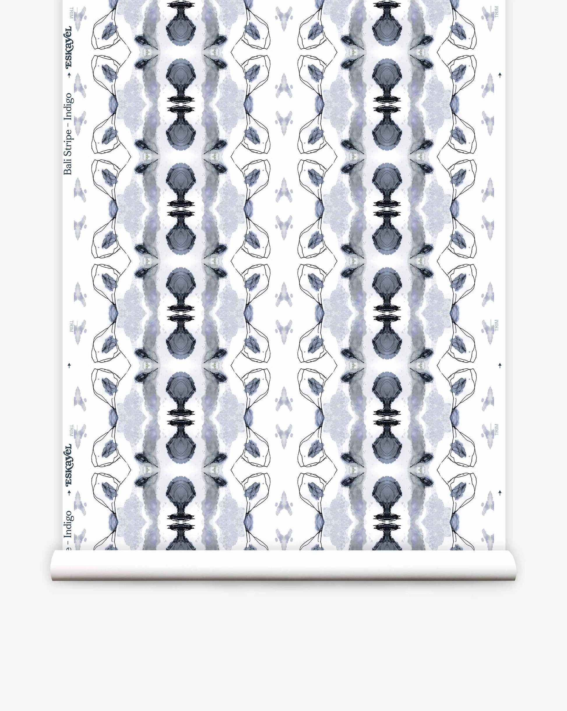 A roll of Bali Stripe Wallpaper||Indigo featuring a symmetrical blue and grey botanical pattern.