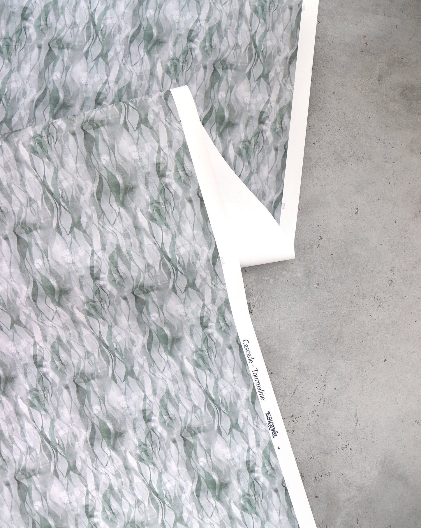 An image of Cascade Tourmaline Wallpaper with green tones and a pattern that invokes the energy of falling water.