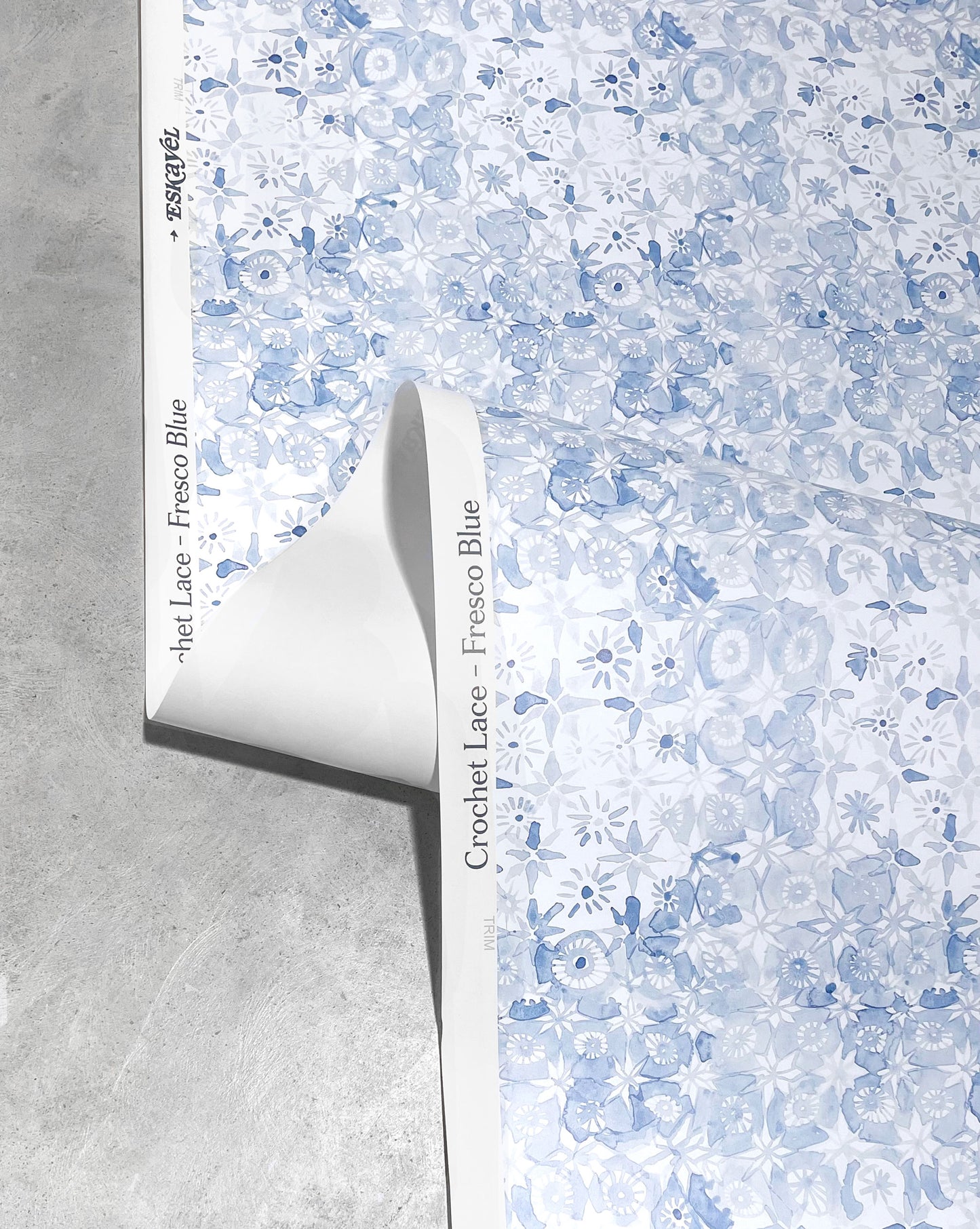 Eskayel’s Crochet Lace wallpaper is a micro-print based on traditional Italian lace. In the Fresco Blue colorway, the palette includes blues and white.