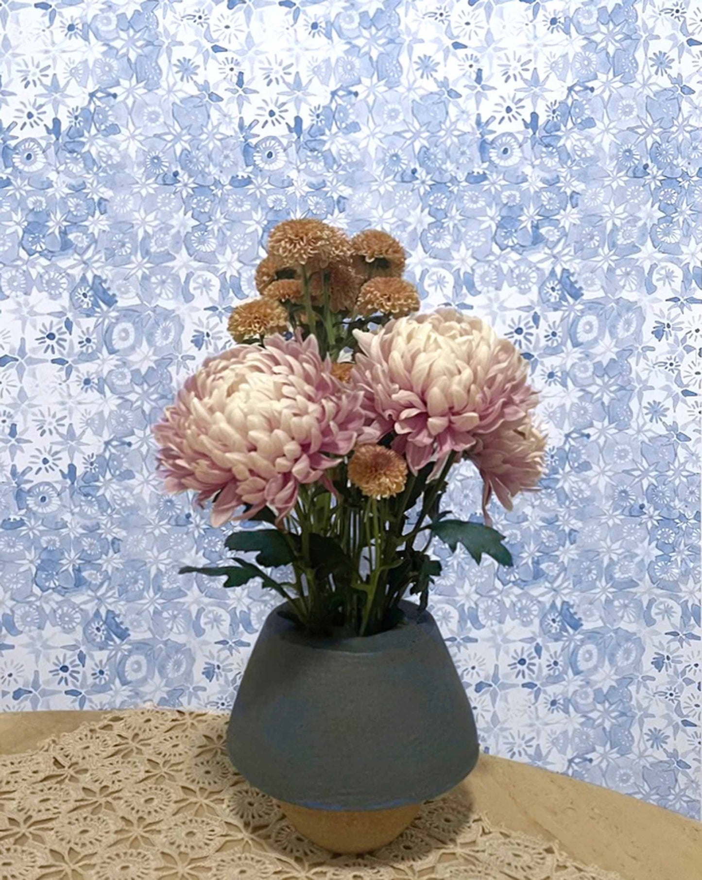 In Eskayel’s Crochet Lace wallpaper in the Fresco Blue colorway, watercolor flowers punctuate a loose network of squares.