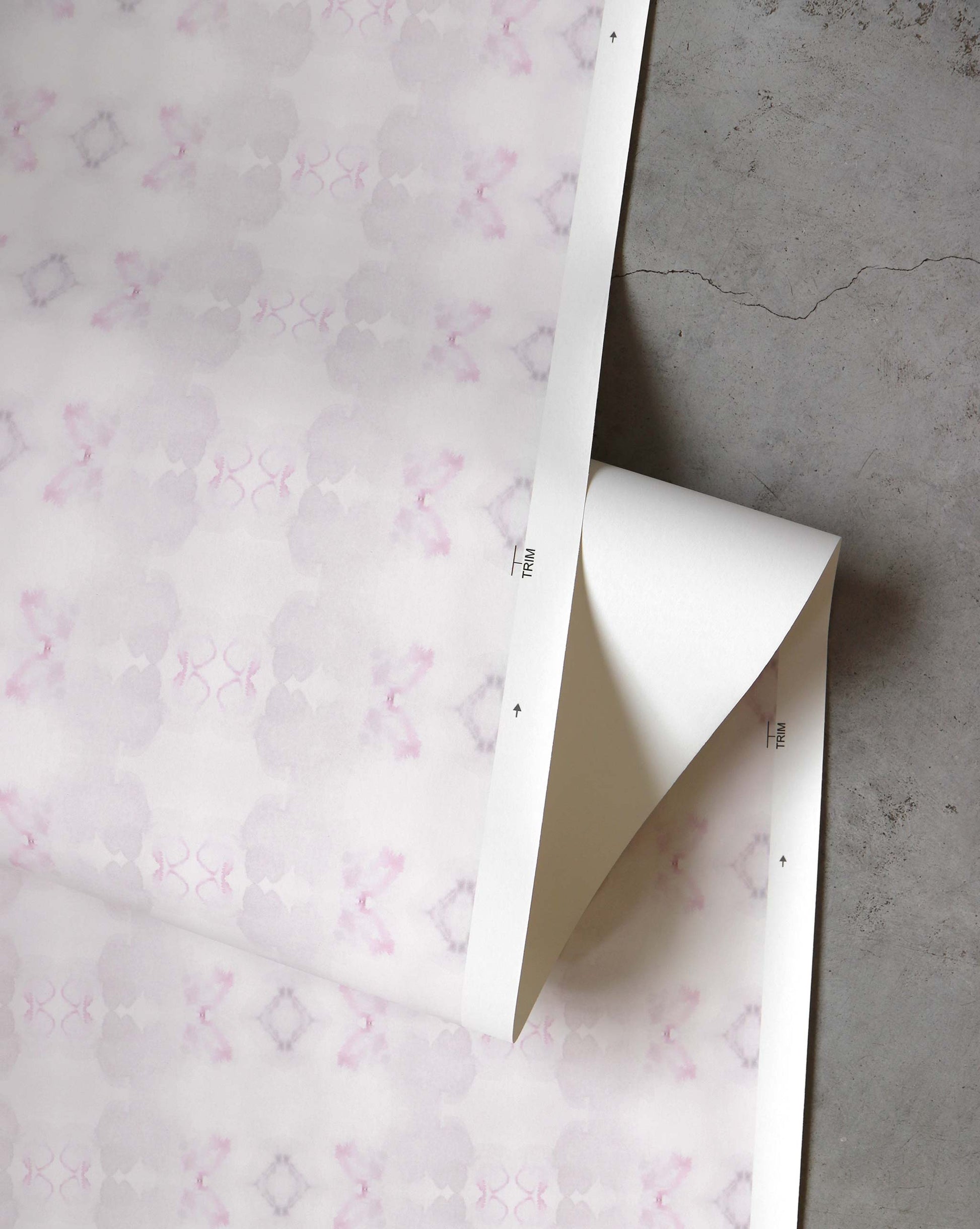 A detail shot of Icelandic Mist Wallpaper in the colorway Rose which features a white and pink pattern.