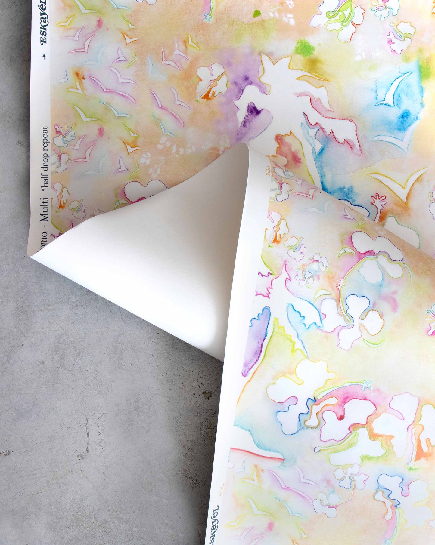 An image of Kokomo Multi Wallpaper with a bright toned palette. The pattern is inspired by a tropical landscape of hibiscus lilies, birds, and palm trees using this idea to create one continuing line.