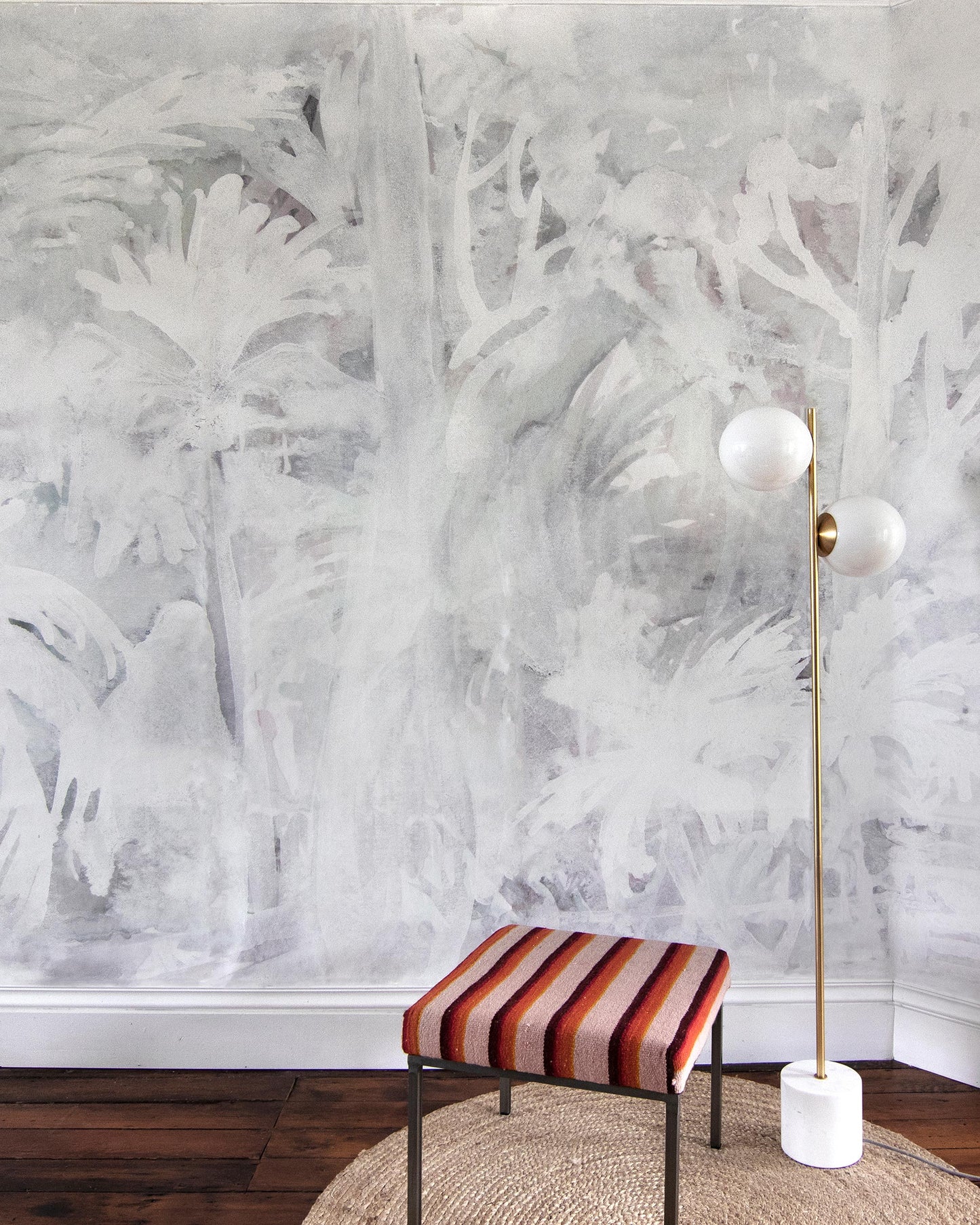 A room with a white wall and a Regalo di Dio Wallpaper Mural striped ottoman