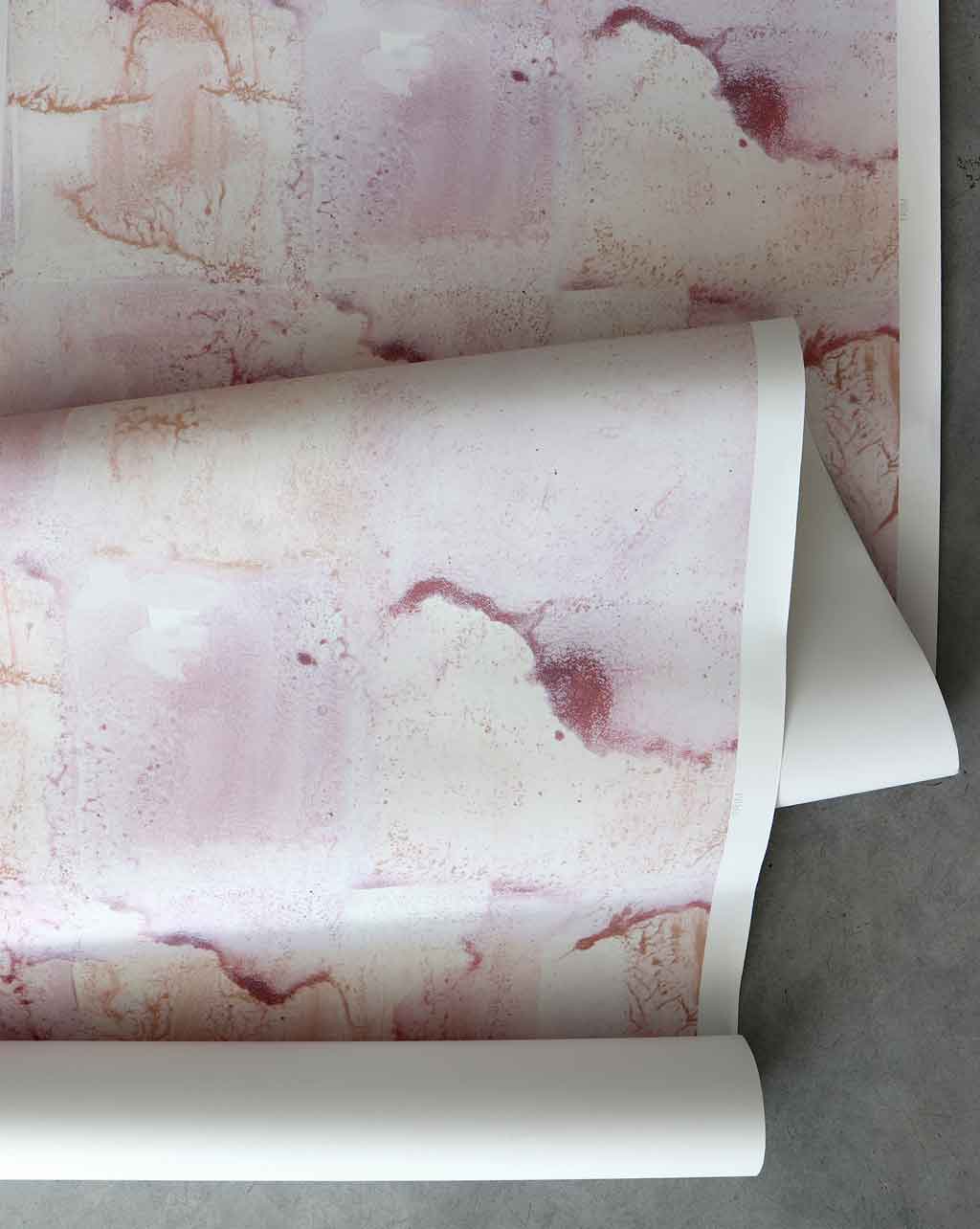 A roll of Melting Checks Wallpaper with pink and white paint on it, offering color options for high-end Terracotta