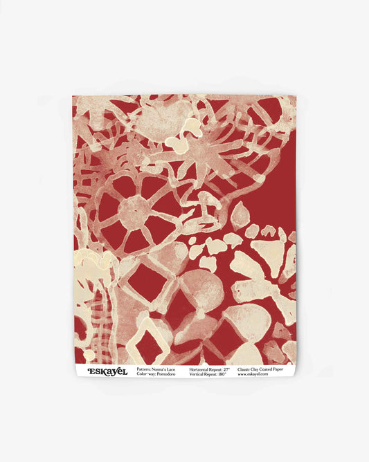 A swatch of Nonna’s Lace in Pomodoro shows a closeup of the large-scale non-repeating wallpaper in red.