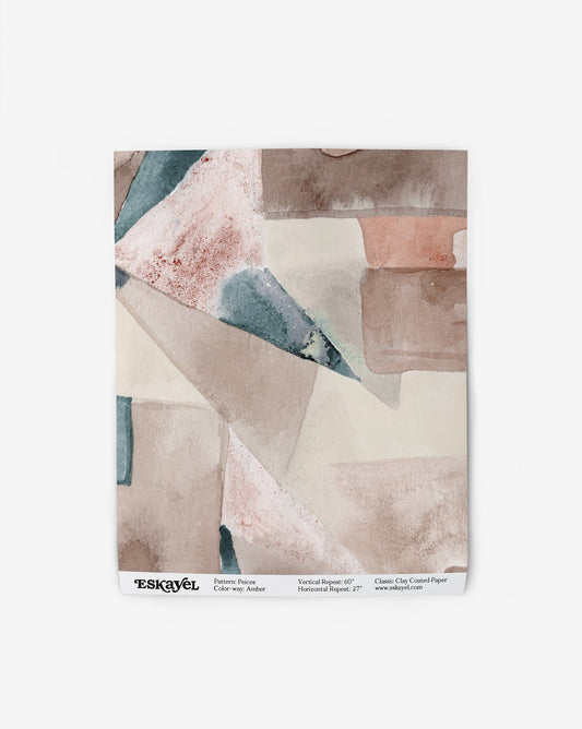 Our Pieces Wallpaper in Amber has a design of color blocked puzzle pieces in an earthy brown, blue, and beige color.