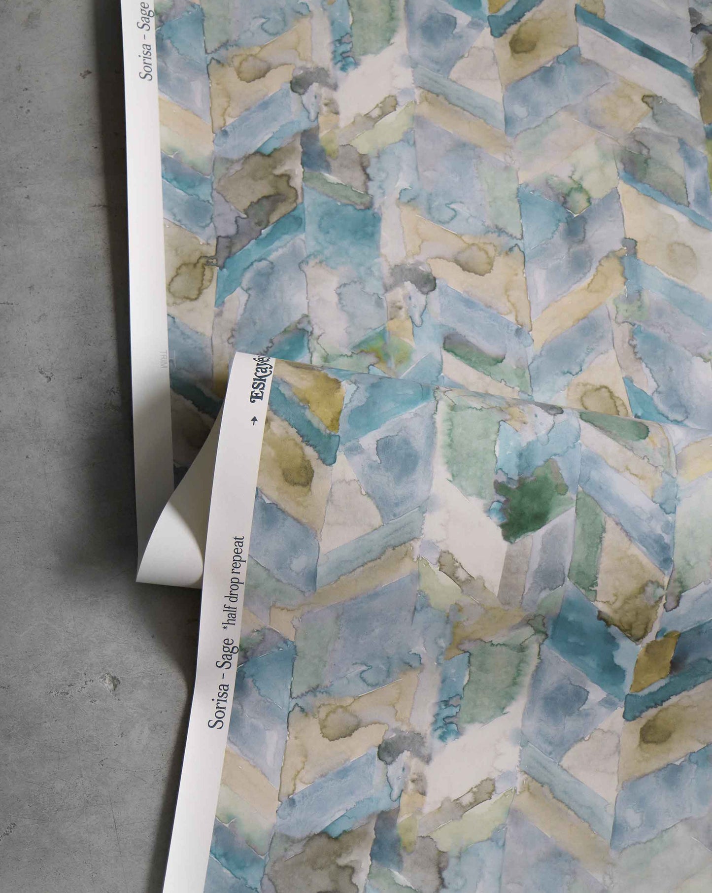 A Sorisa Wallpaper Sage chevron wall hanging with a tropical watercolor pattern